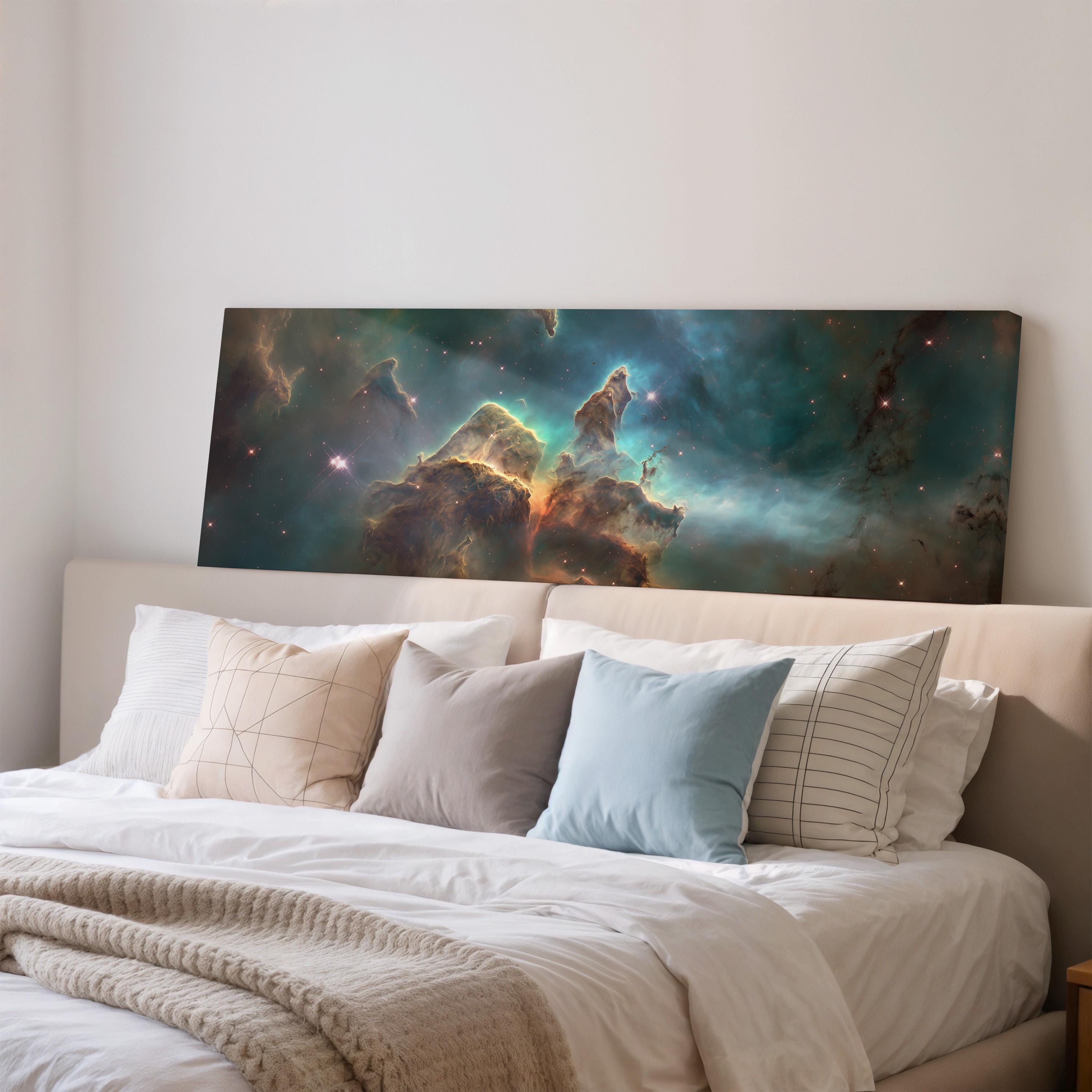 a large, colorful painting of a nebula hanging on a wall above a bed with white bedding and pillows.