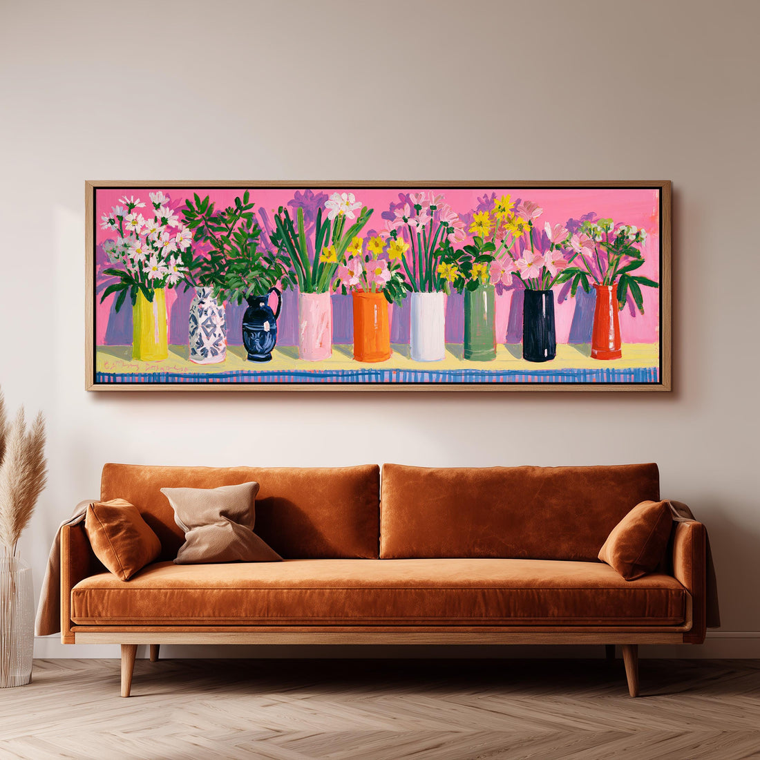 Folk art bouquets in colorful vases on pink long horizontal canvas print above a sofa in a living room