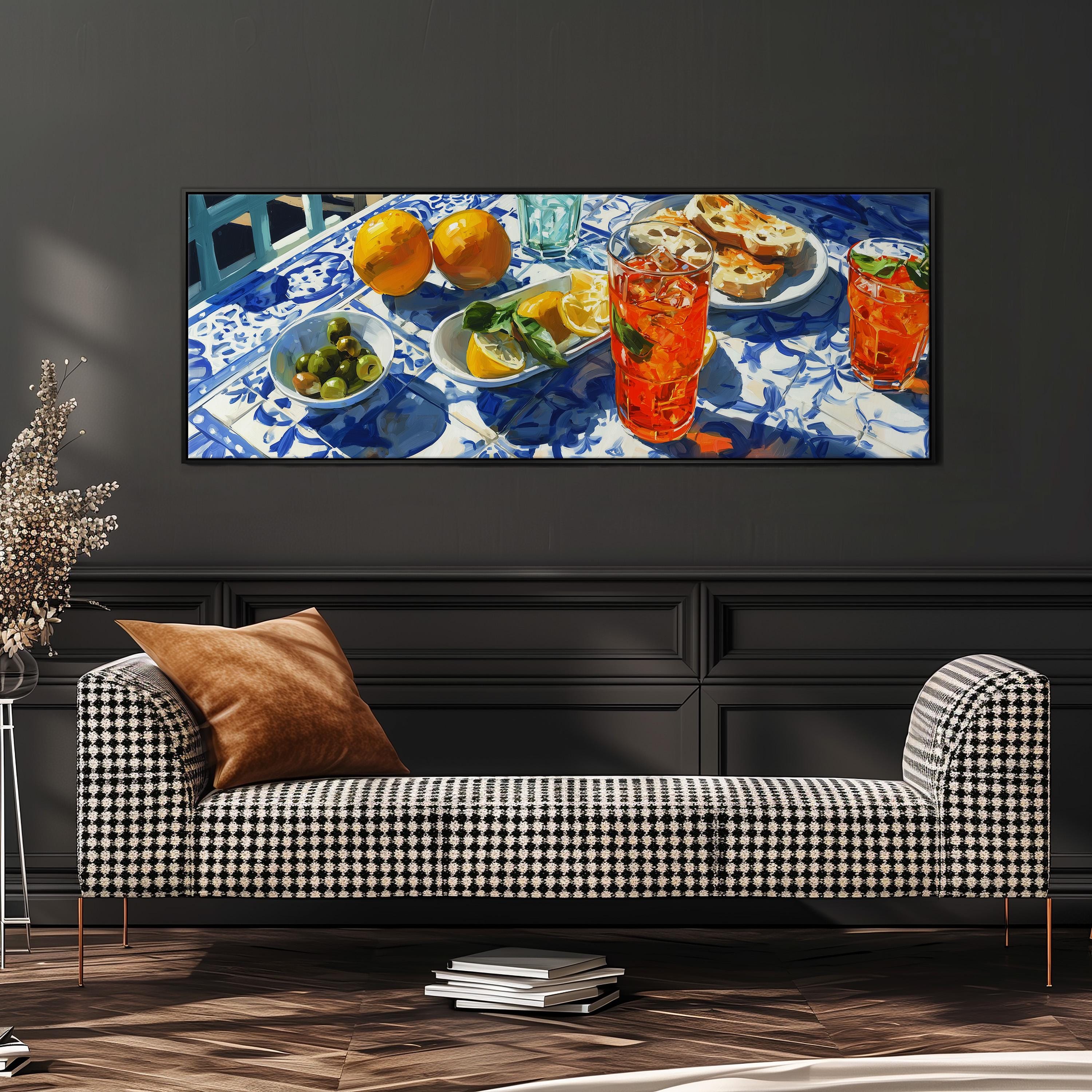 a checkered sofa with a stack of books on the floor in front of it, and a large painting of a table with various food items and drinks displayed on it.
