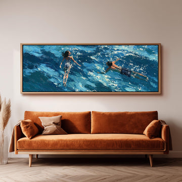 Two swimmers in turquoise waves long horizontal canvas print above a sofa in a living room