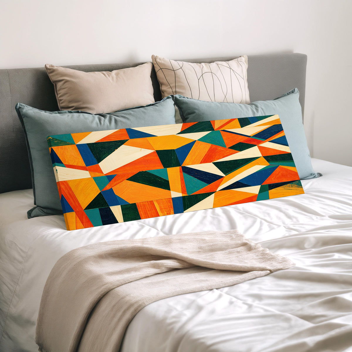Orange and teal triangle mosaic wide panoramic canvas print laid on a bed to show its size