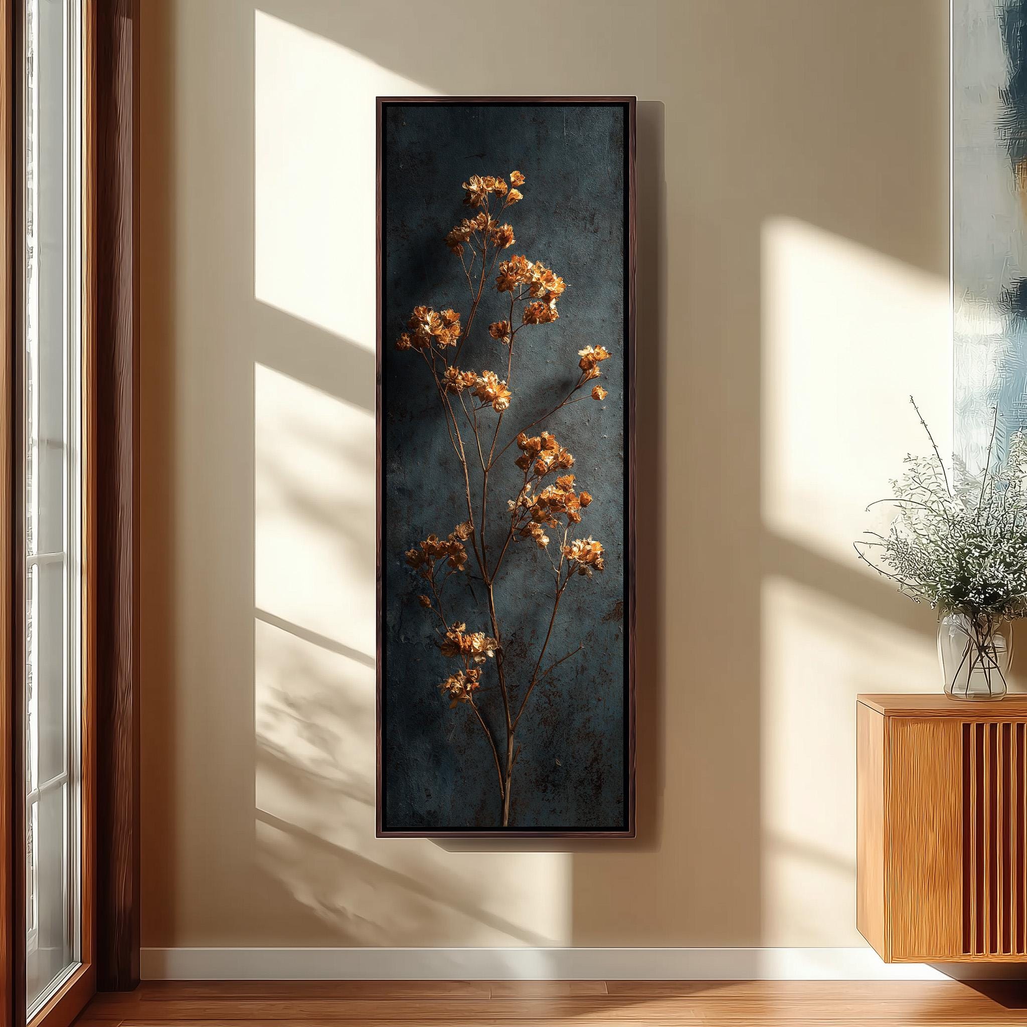 a large framed painting of a plant with orange flowers hanging on a wall in a room with a wooden floor and a window.