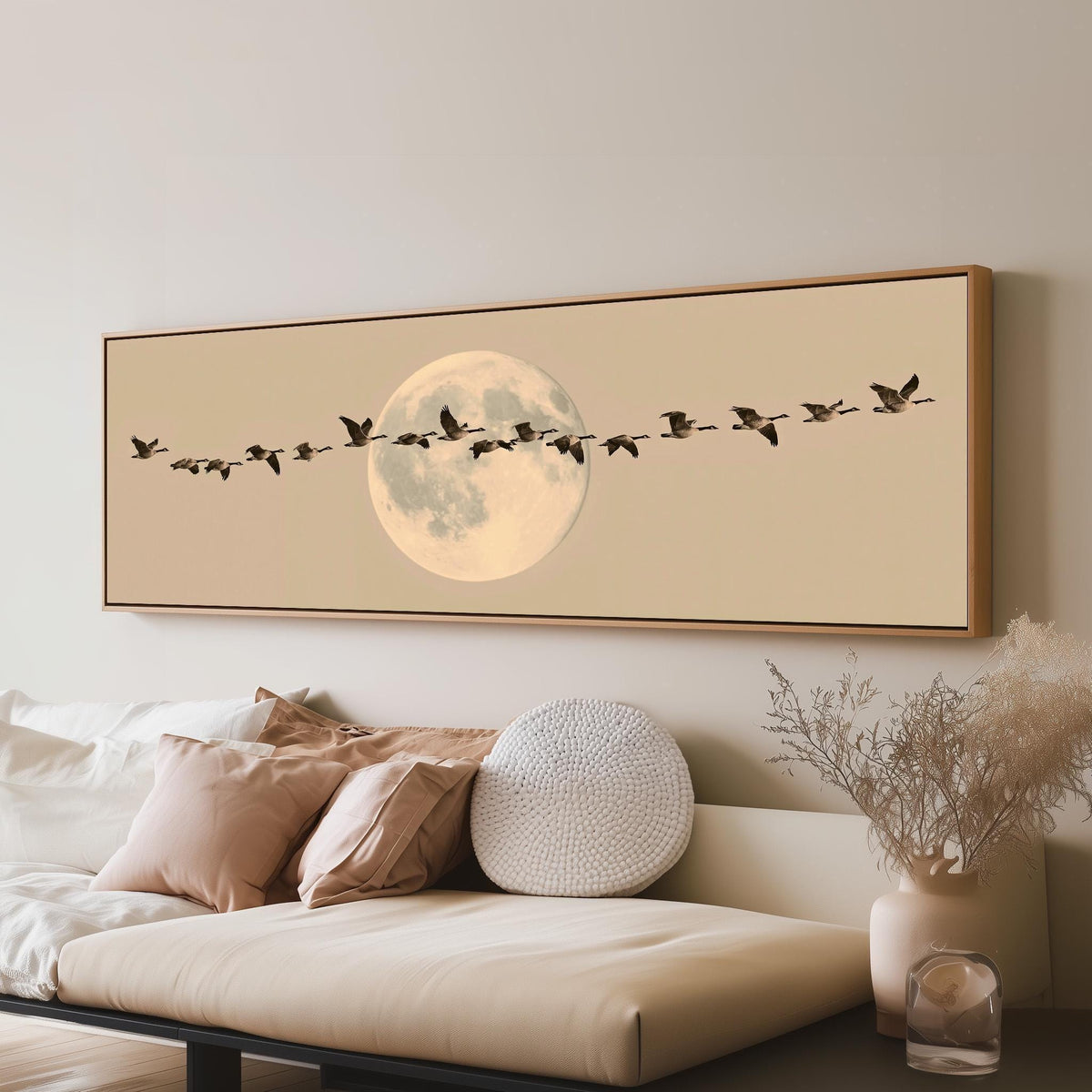 Geese flying across a pale moon on sand long horizontal canvas print above a sofa in a living room
