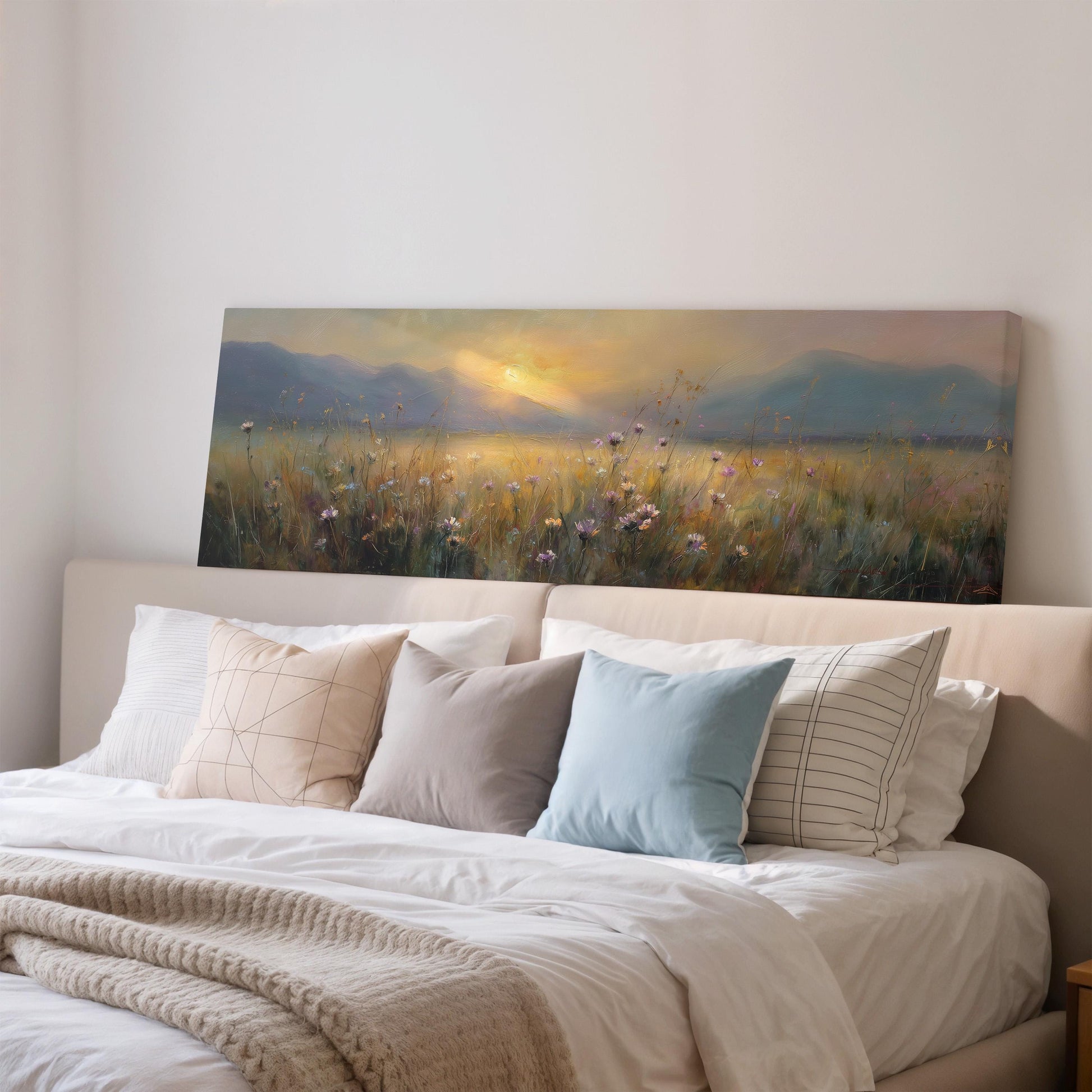 a large painting of a field with flowers hanging above a bed with white linens and pillows.