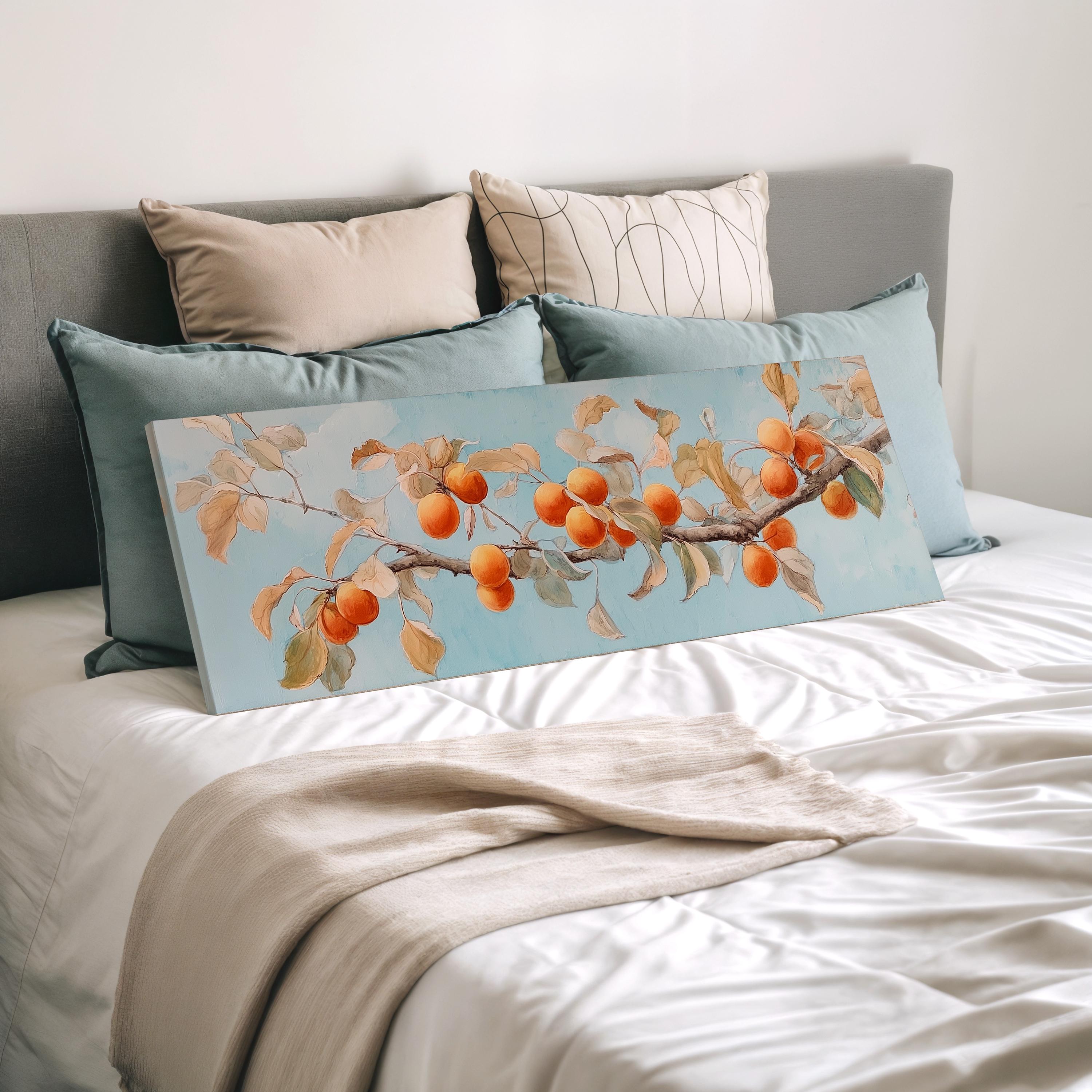 a bed with a large canvas print of a tree branch with orange fruits on it, placed on top of a white comforter.
