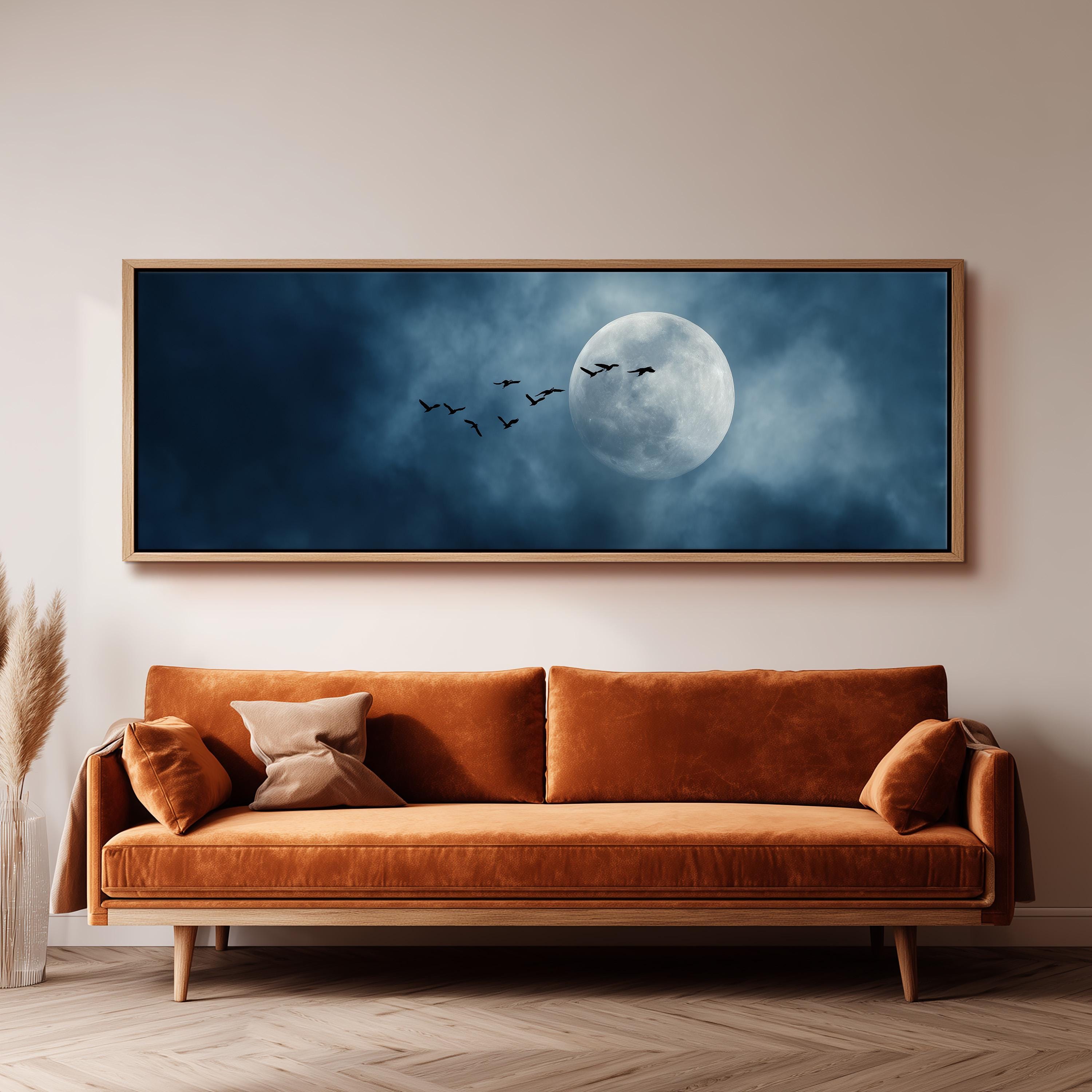 a large, framed painting of a night sky with a full moon and a flock of birds flying across it.