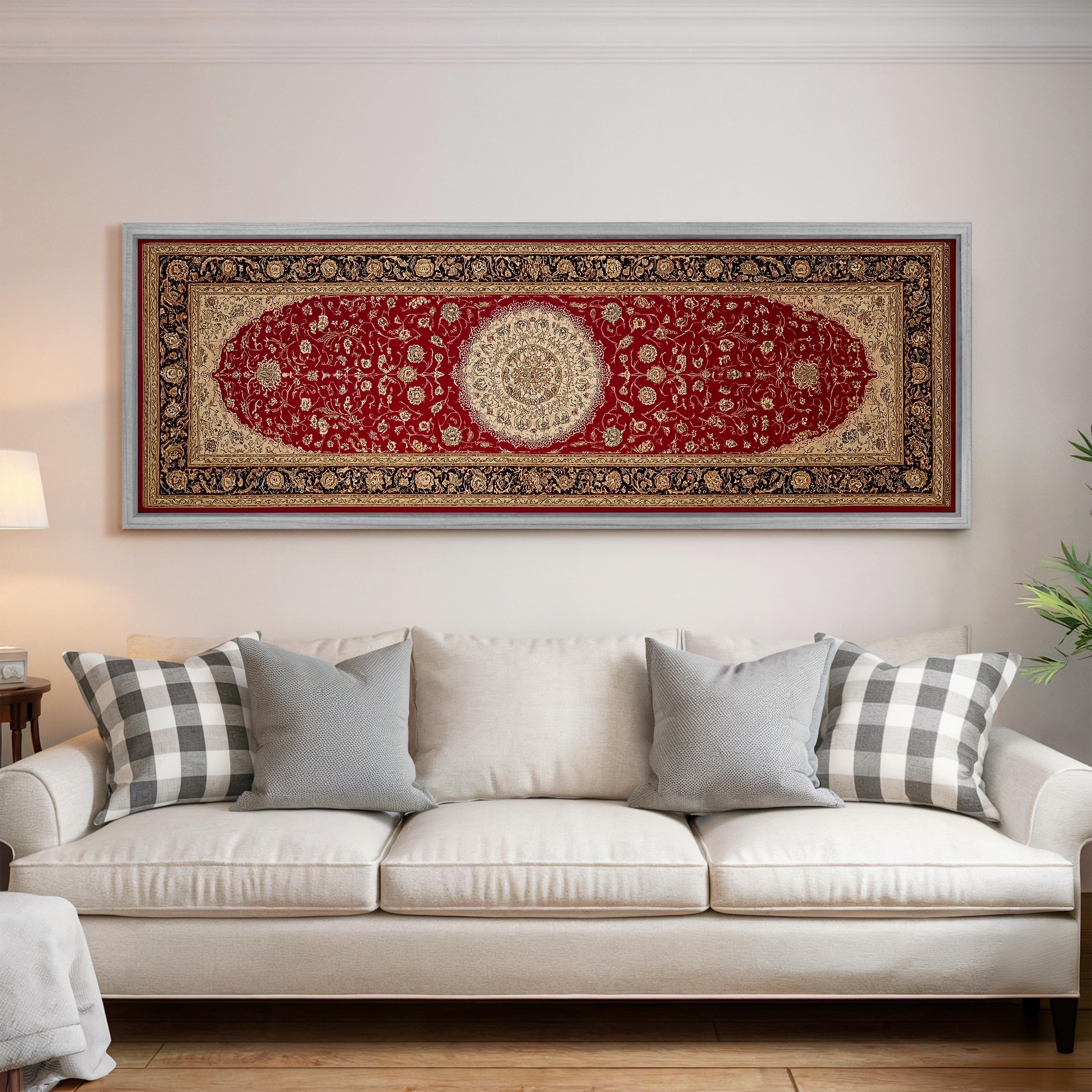 a large, ornate red and gold rug hanging on a white wall above a white sofa with gray and white plaid throw pillows.