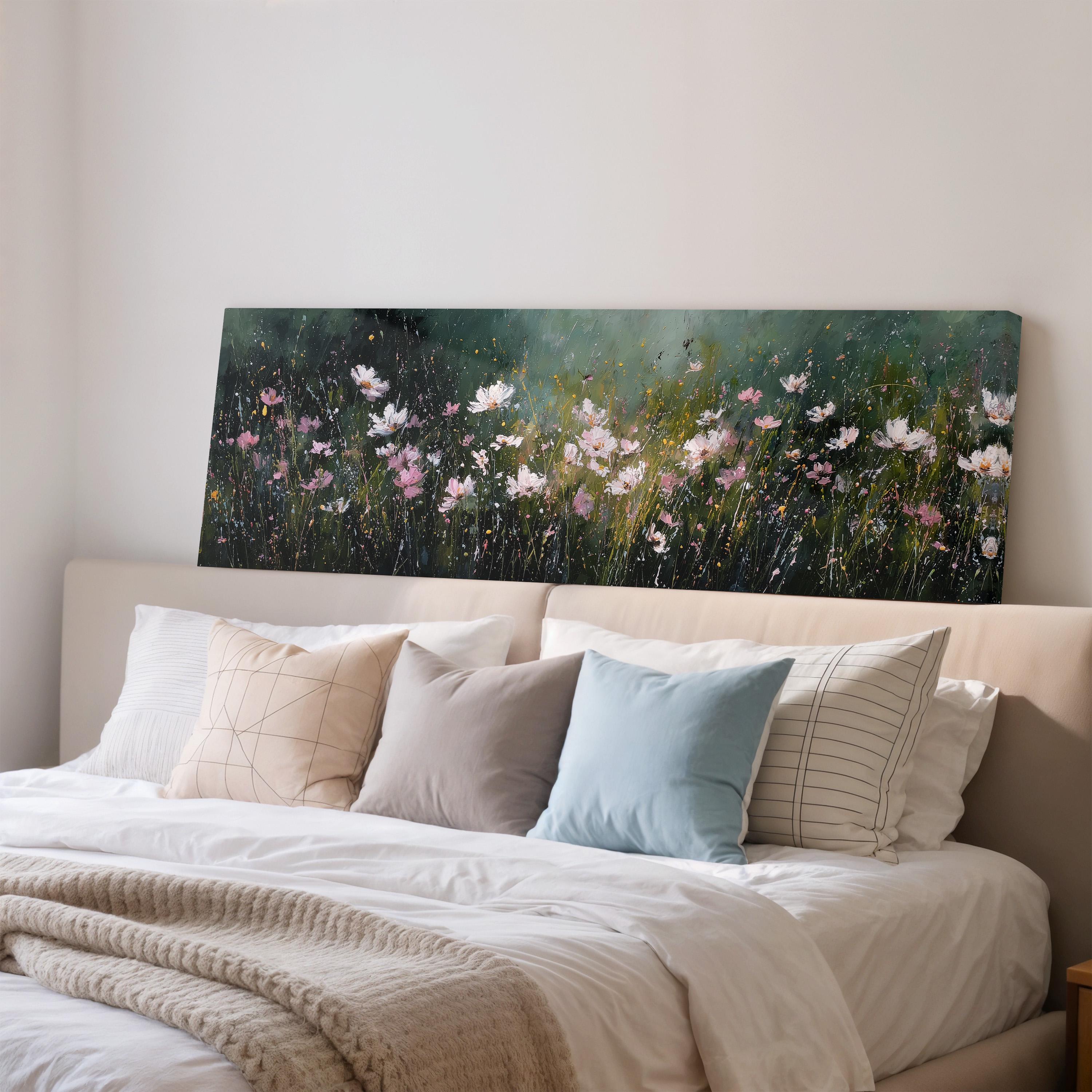 a bedroom with a large bed covered in white sheets and pillows. Above the bed, there is a painting of a field of flowers, creating a serene and peaceful atmosphere in the room.