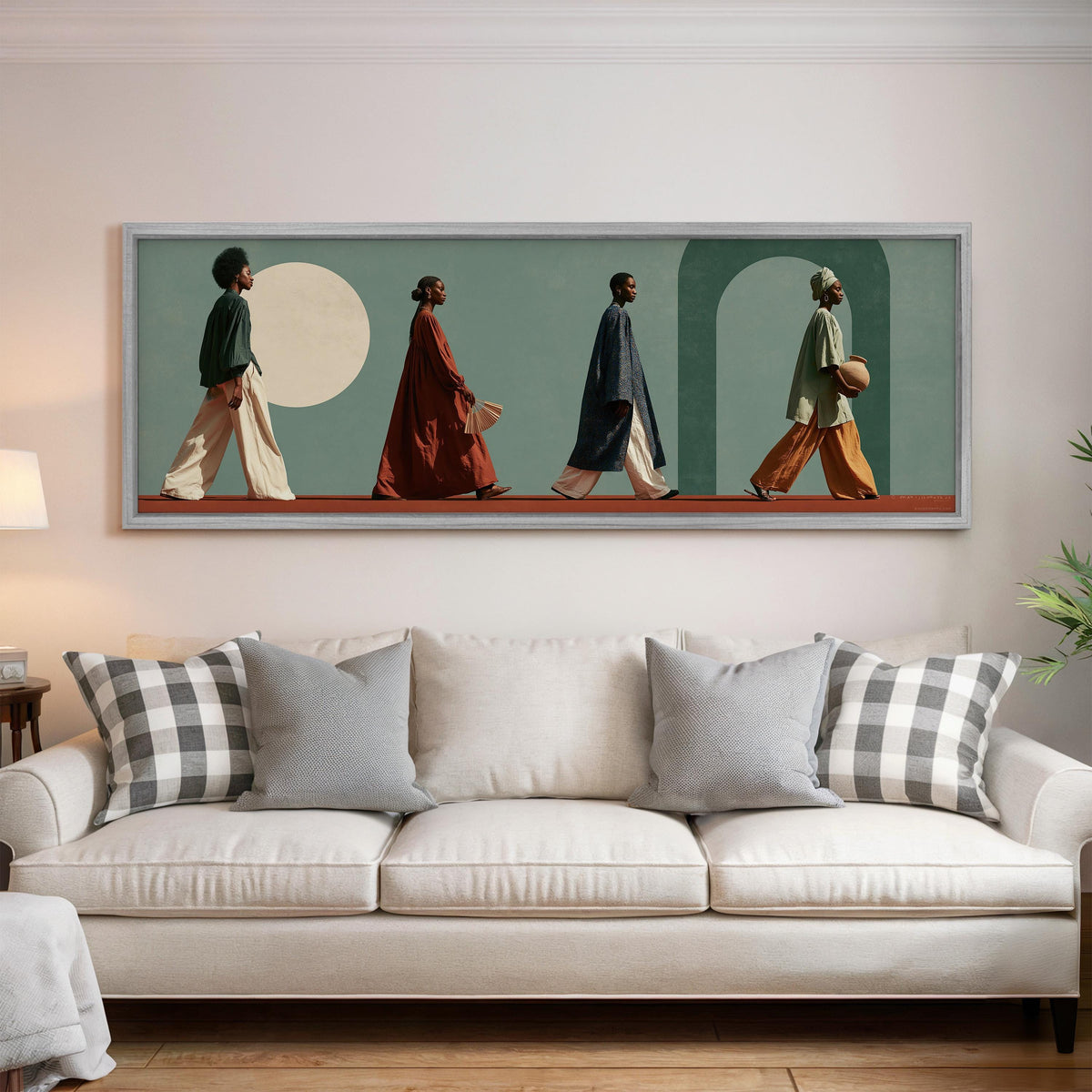 Women walking past arches and a pale moon panoramic canvas print above a white sofa in a bright living room