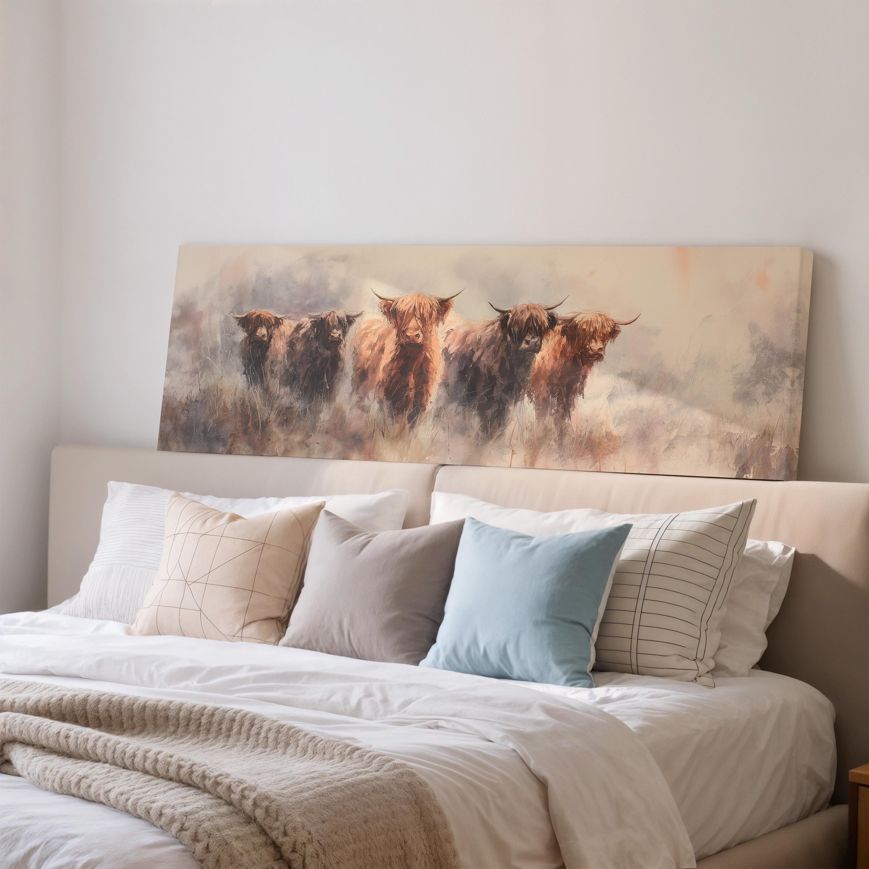 a large painting of a group of cows on a bed with white pillows and a gray blanket.