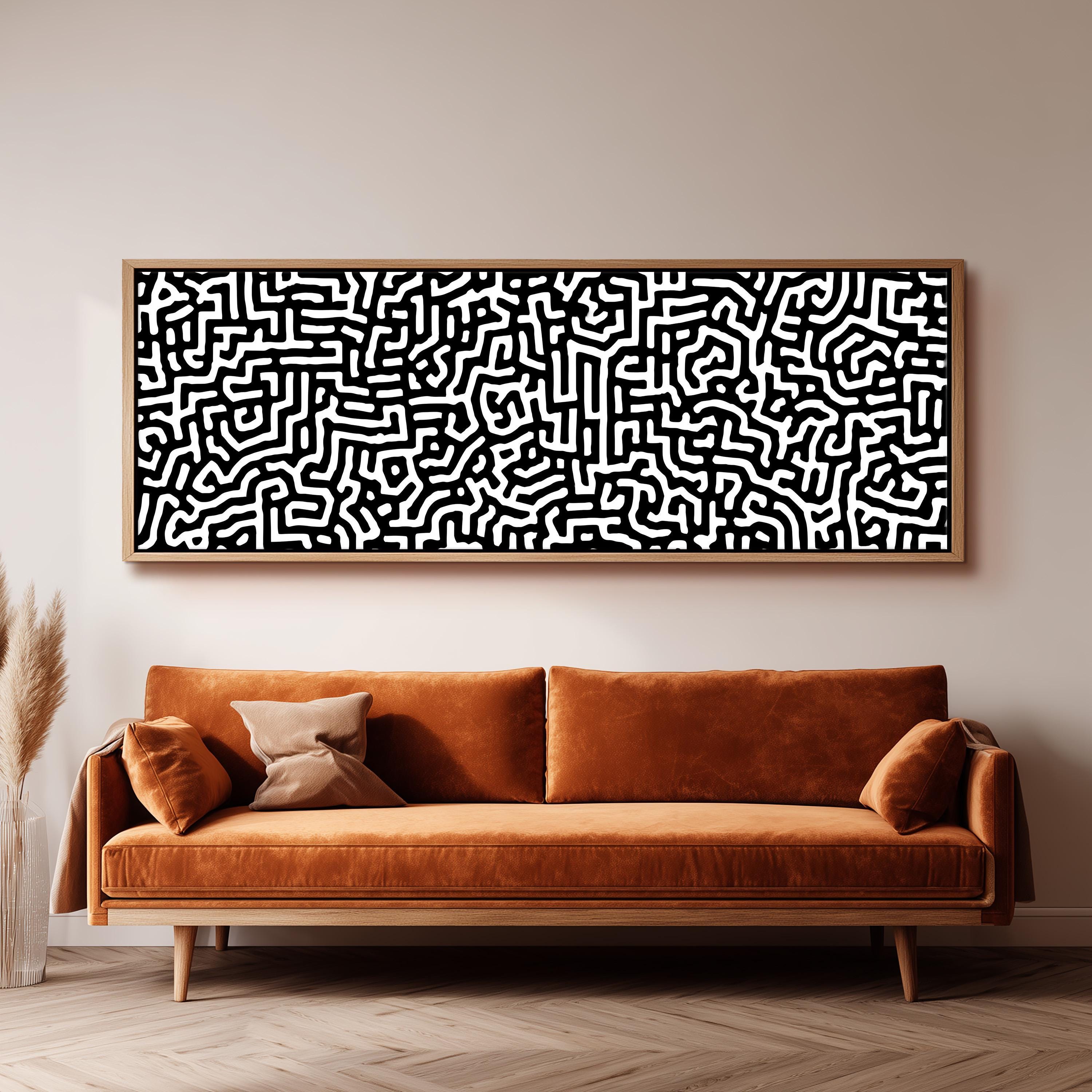 a large, abstract black and white painting hanging on a wall above a brown sofa.