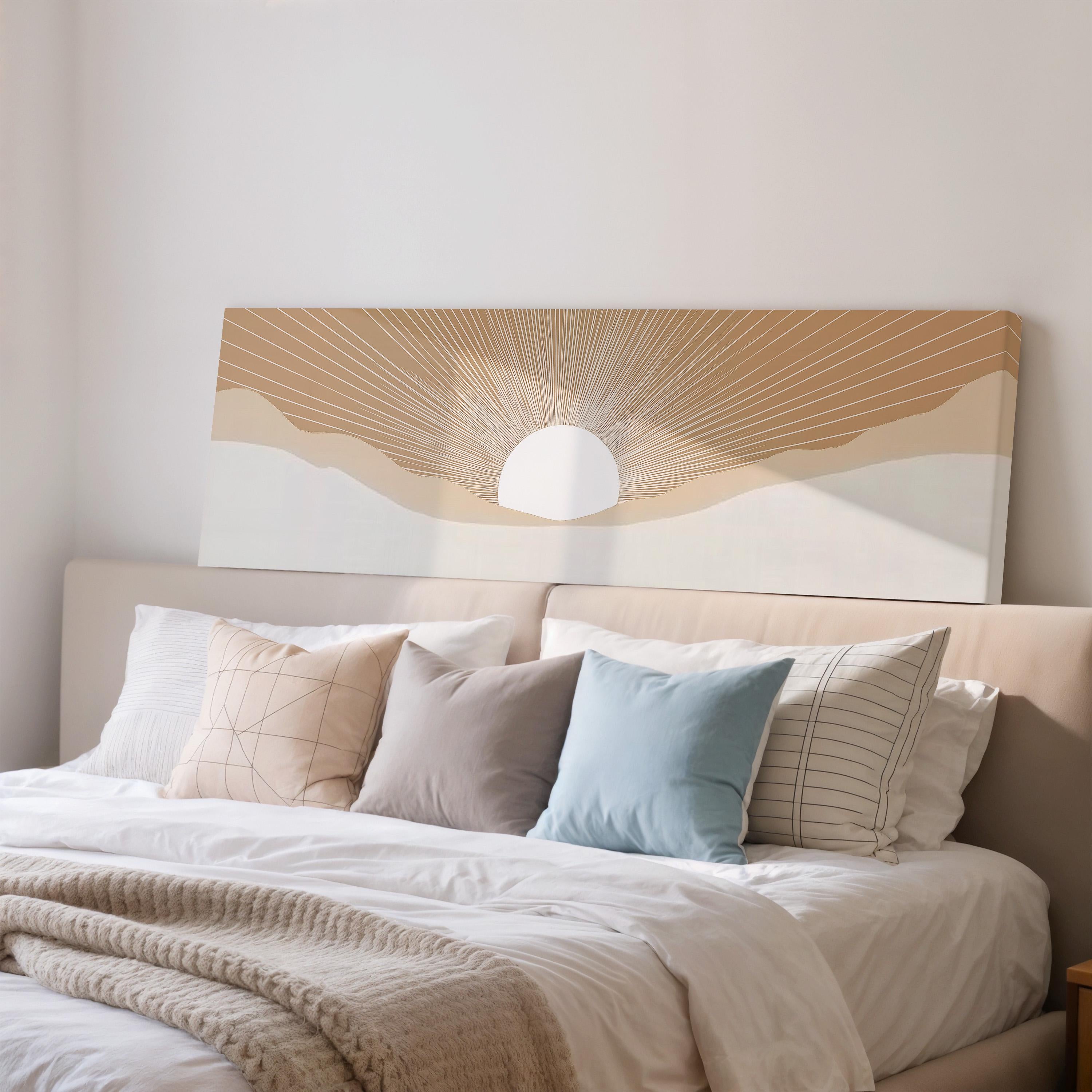 a cozy bedroom with a large bed adorned with a variety of pillows, including a blue pillow and a striped pillow. Above the bed, there is a large canvas print depicting a sun-like design with a sun and rays.