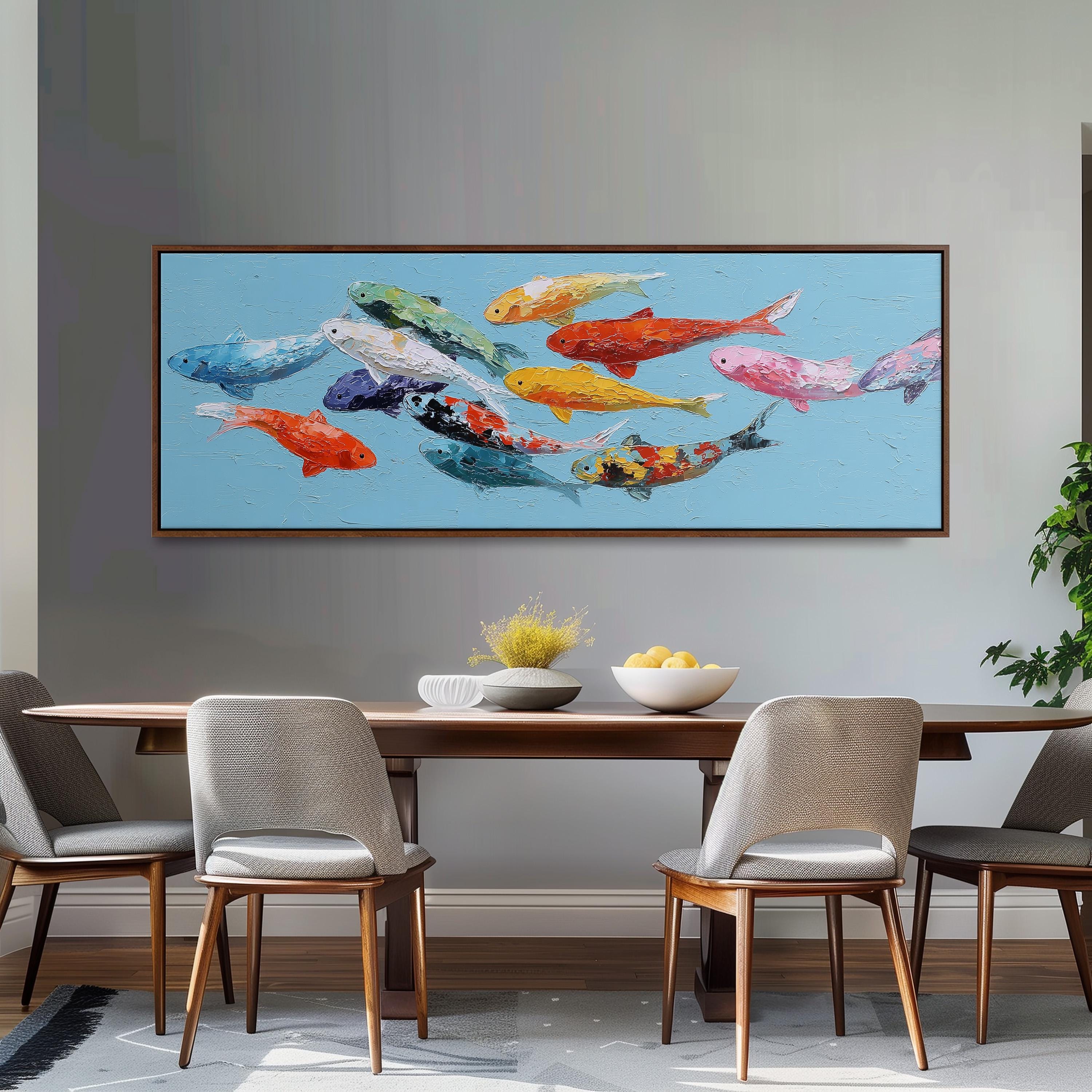 a large painting of colorful fish swimming in the ocean, hanging on a wall above a wooden dining table with four chairs.