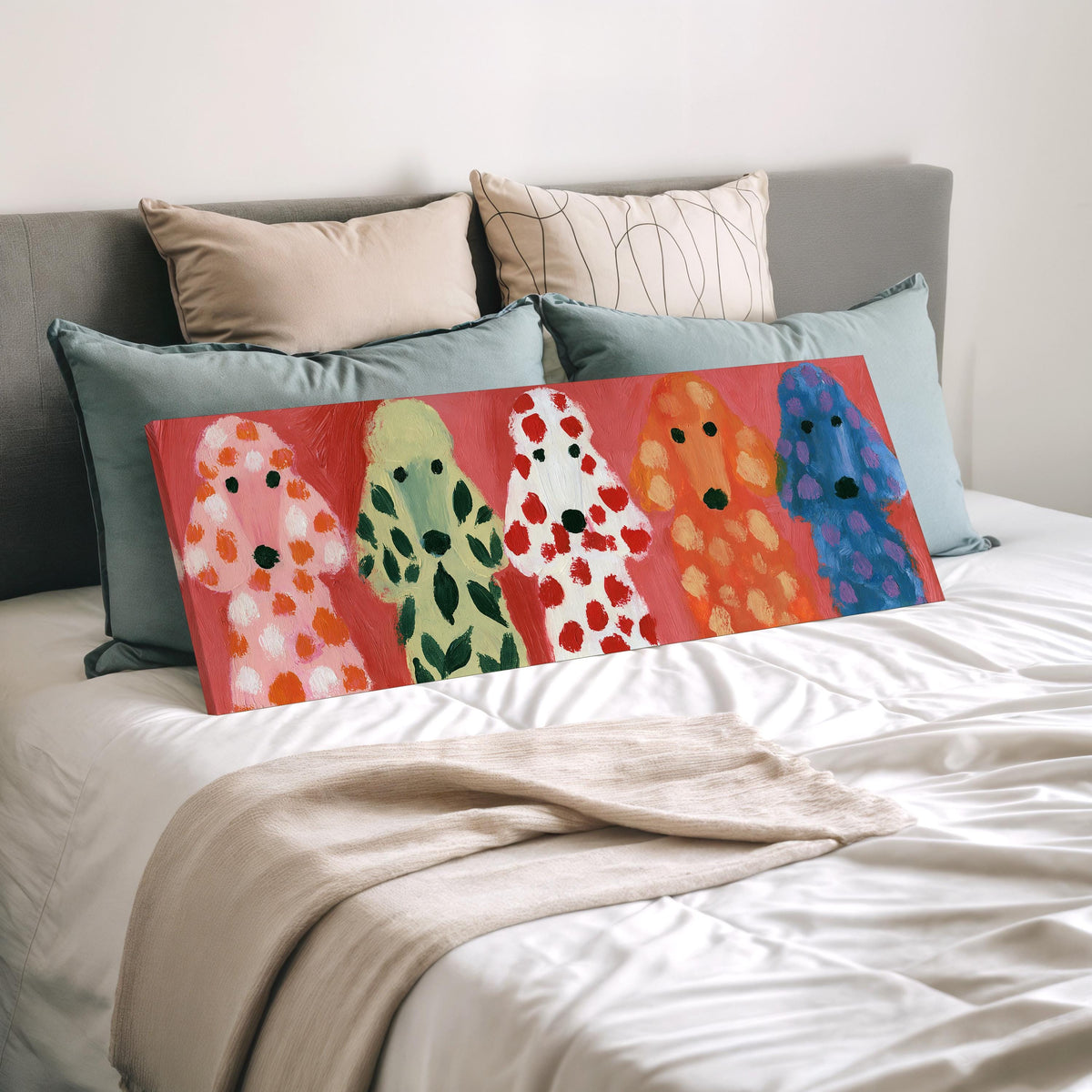 Five colorful poodles wide panoramic canvas print laid on a bed to show its size