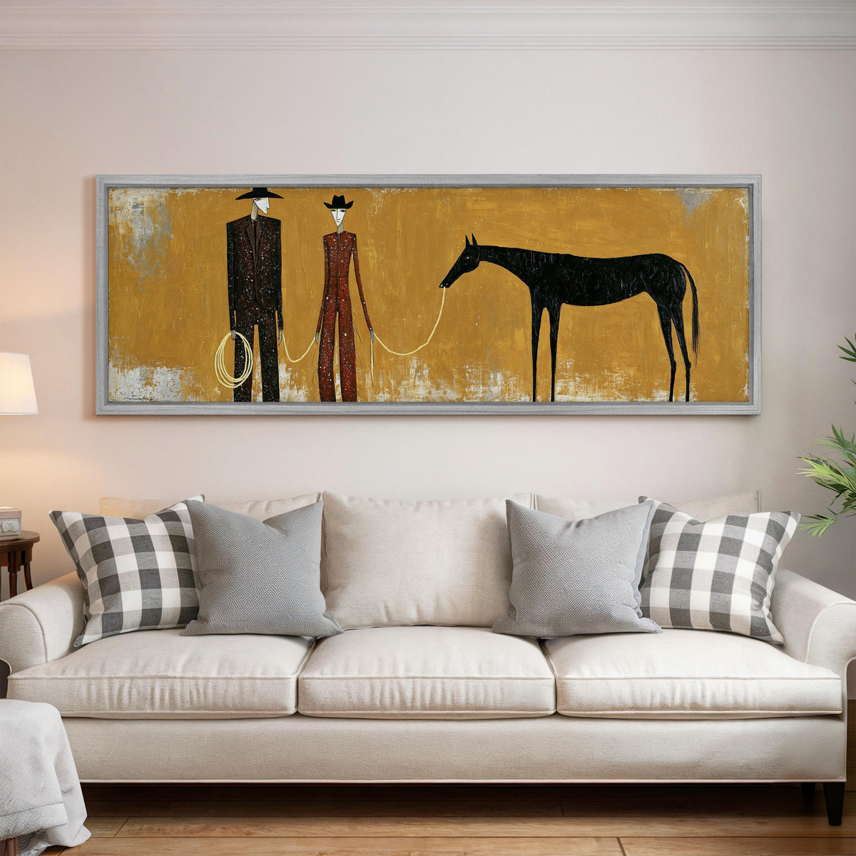 Two cowboys with a dark horse on gold panoramic canvas print above a white sofa in a bright living room