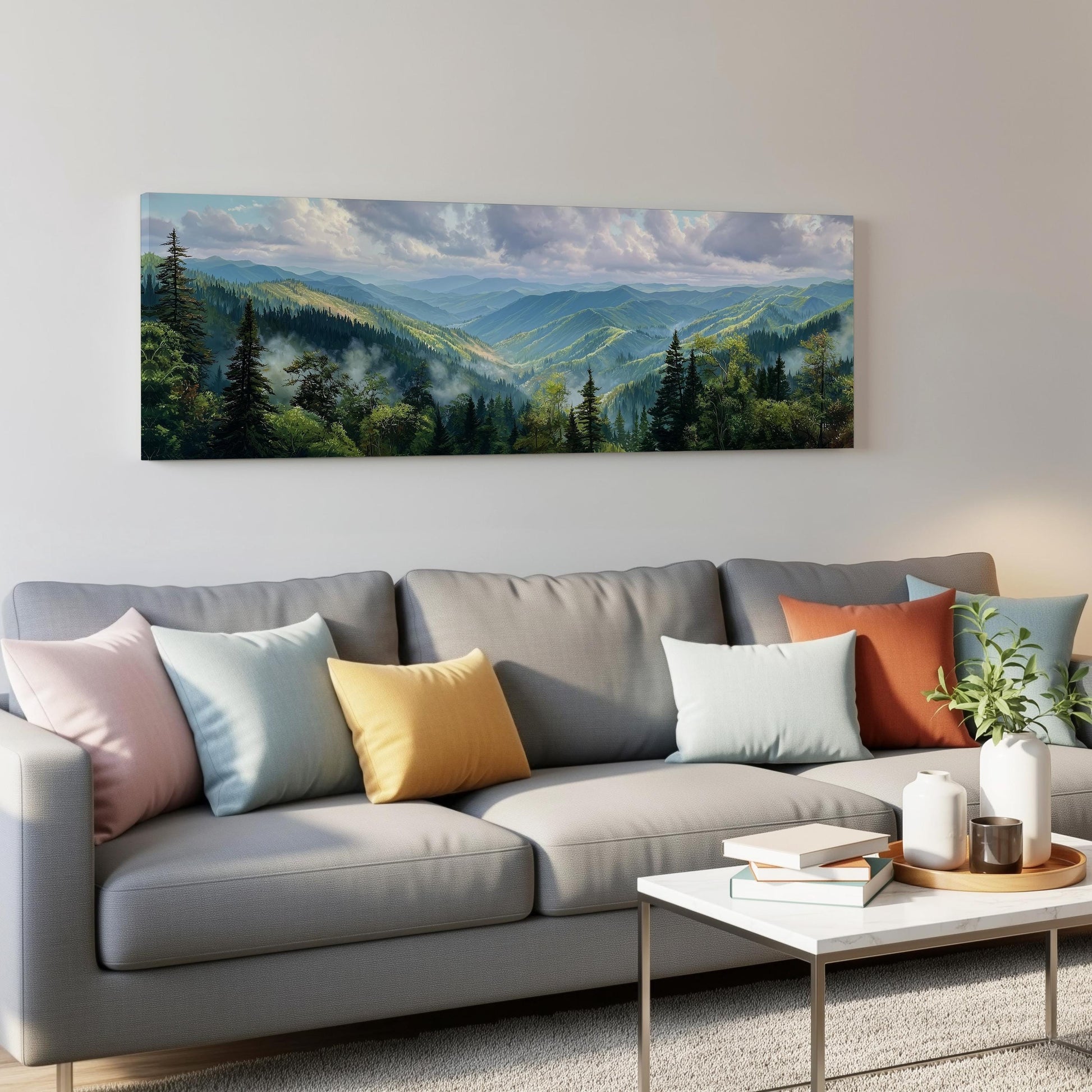 a large landscape painting hanging on a wall above a gray couch with colorful throw pillows. The painting depicts a scenic mountain range with lush forests and a cloudy sky.