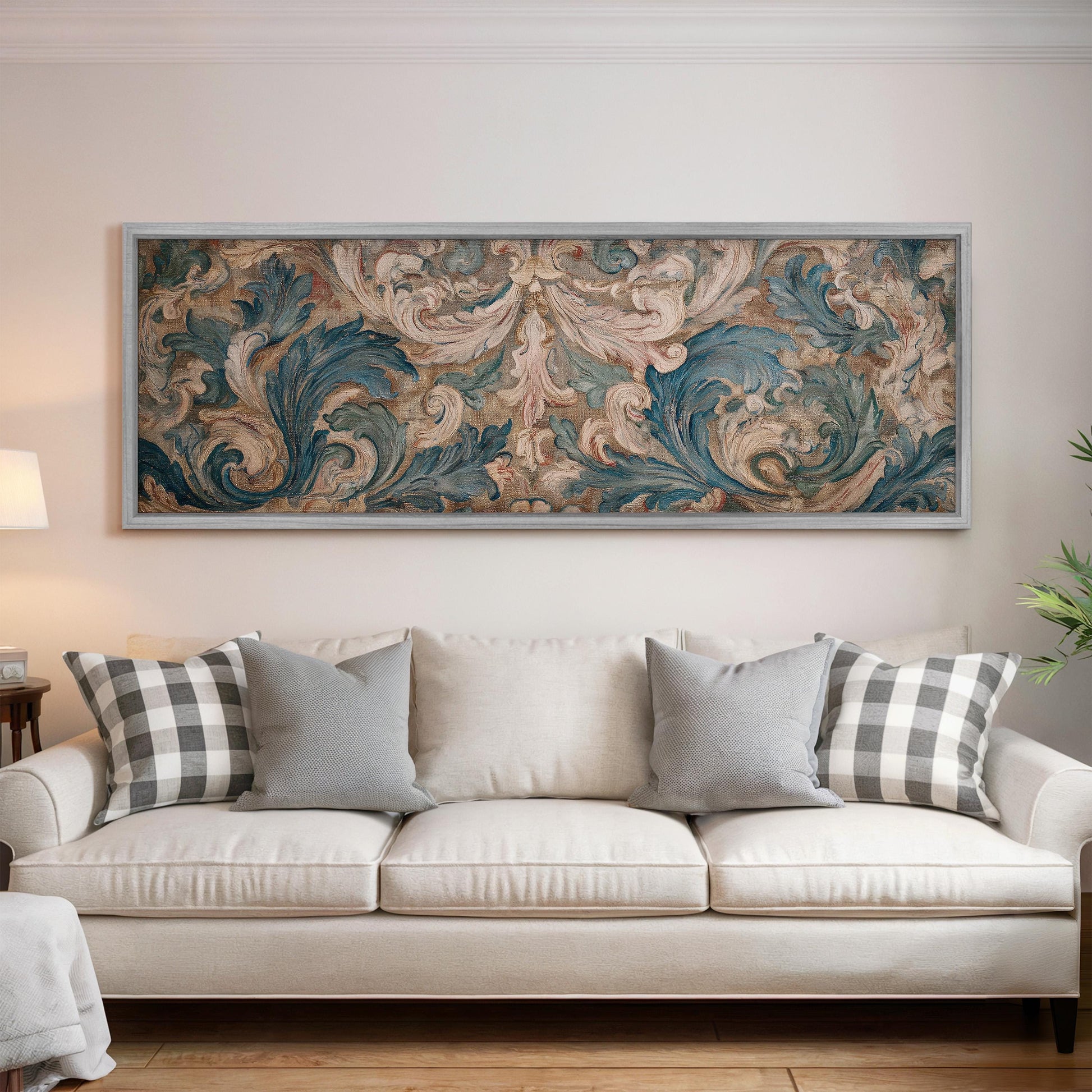 a large, ornate painting hanging on a wall above a white sofa with gray and white patterned throw pillows.