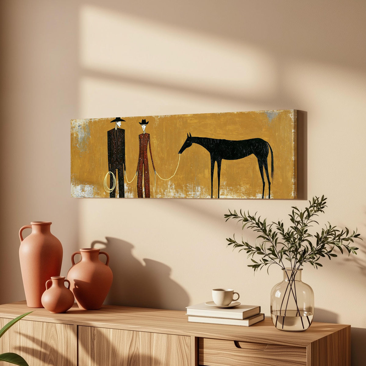 Two cowboys with a dark horse on gold long horizontal canvas print above a wooden sideboard