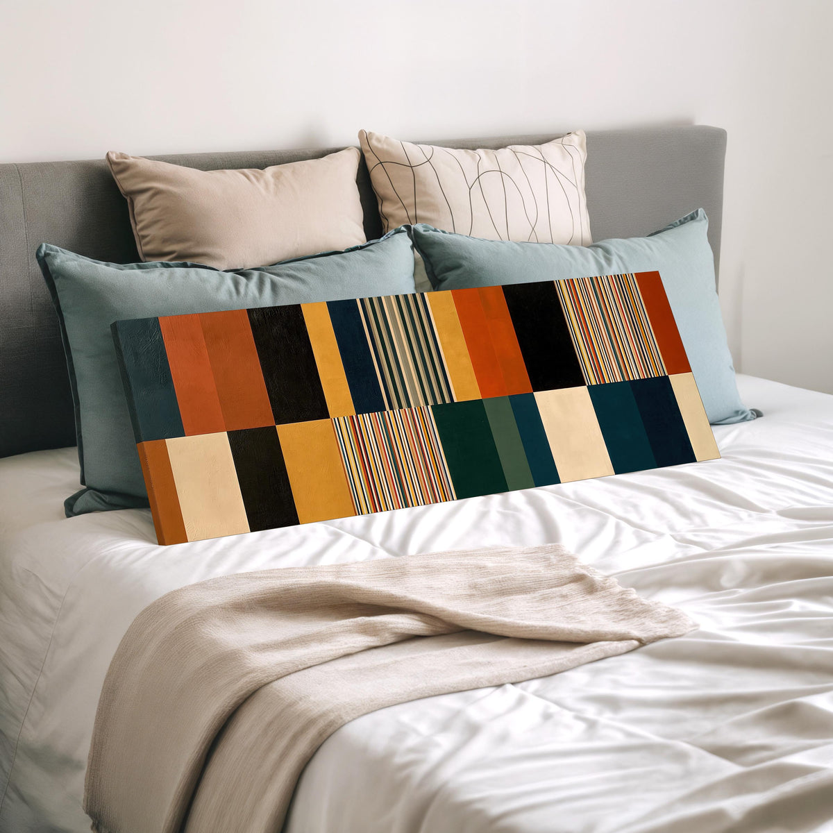 Autumn and teal stripe color blocks wide panoramic canvas print laid on a bed to show its size