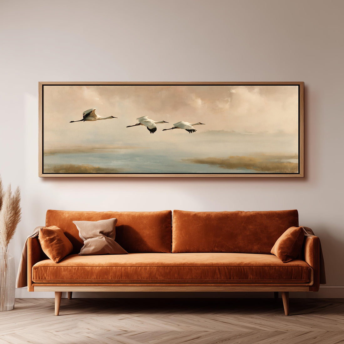 Cranes flying over a calm shore at dusk long horizontal canvas print above a sofa in a living room