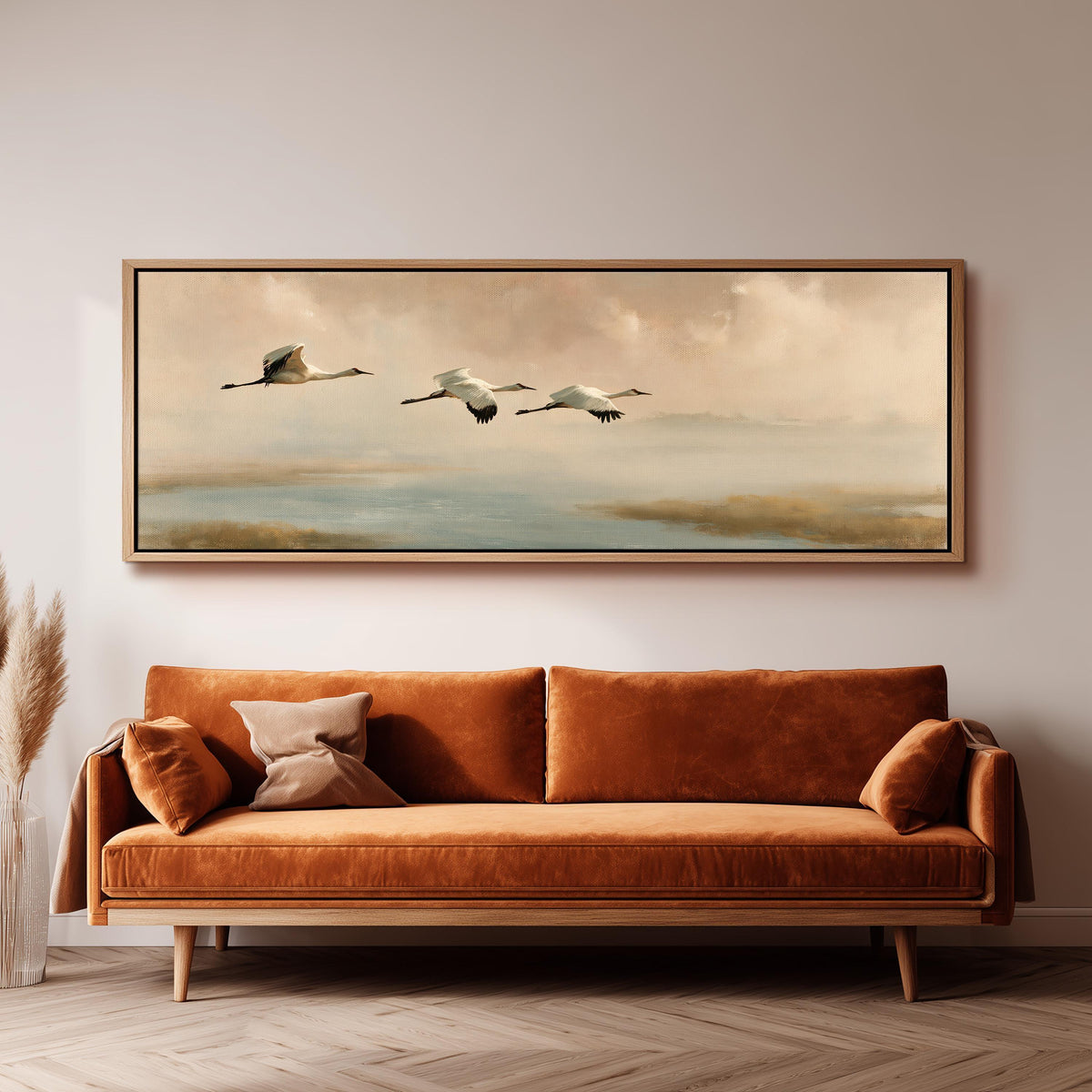 Cranes flying over a calm shore at dusk panoramic canvas print above a sofa in a living room