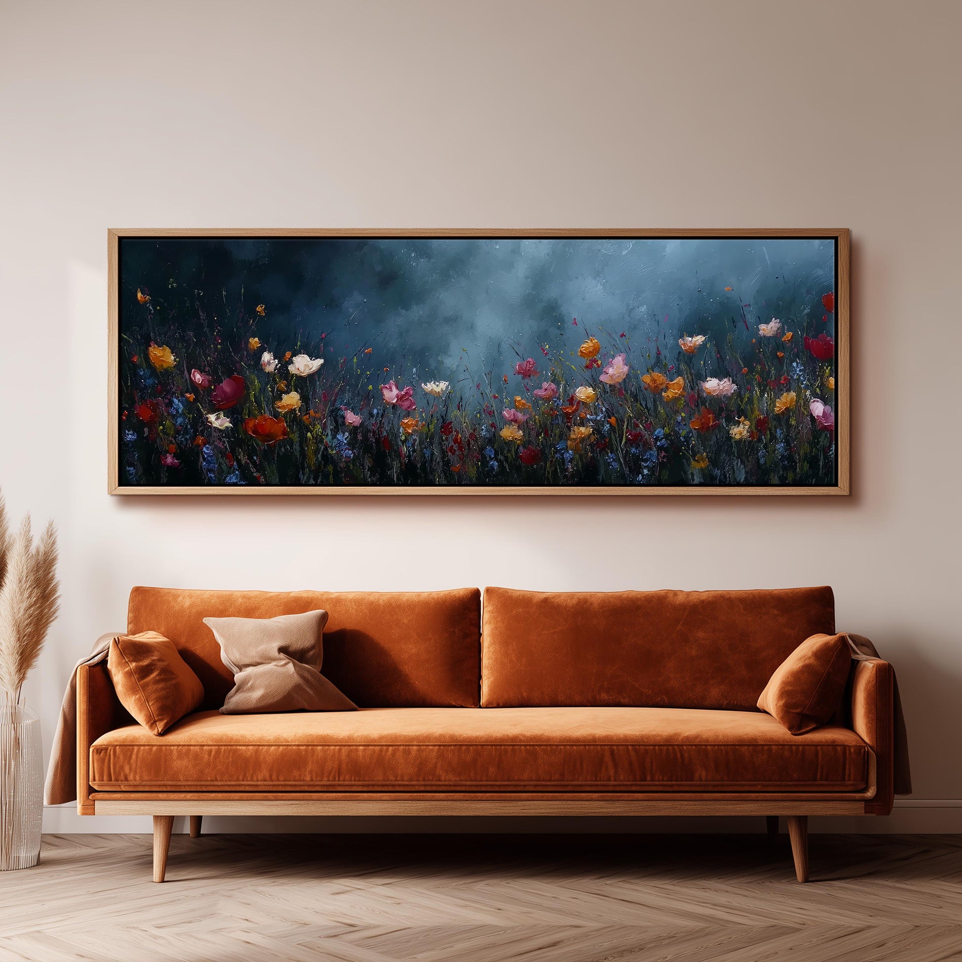 a large, framed painting of a field of colorful flowers hanging on a wall above a brown sofa.