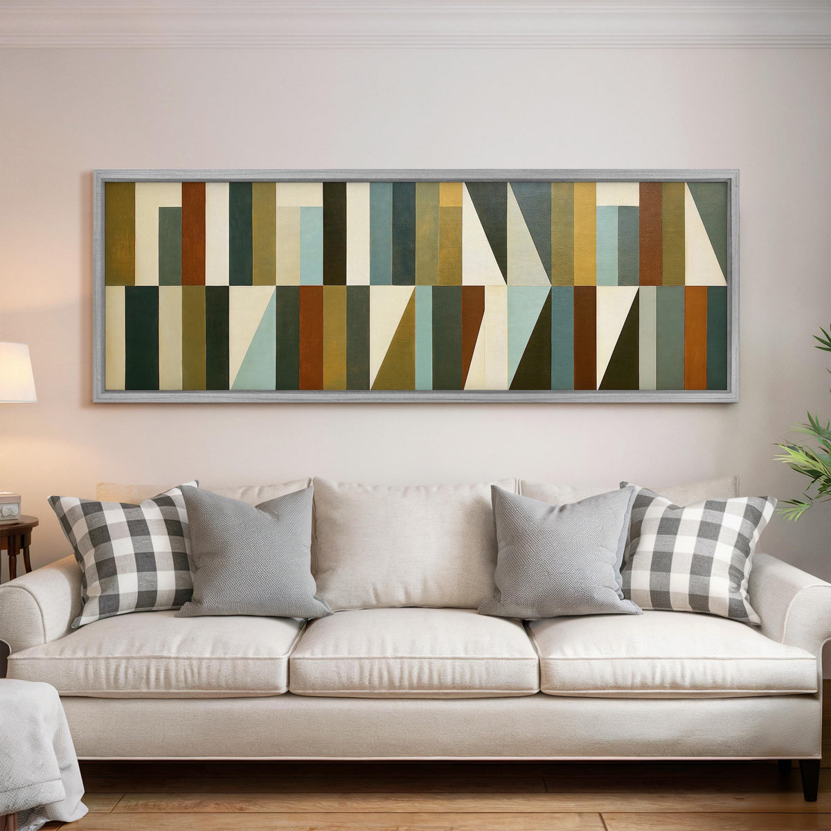 Earth tone geometric triangles panoramic canvas print above a white sofa in a bright living room