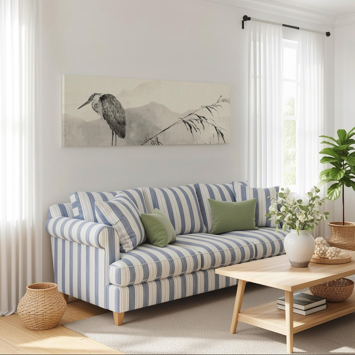 Heron in front of misty ink mountains long horizontal canvas print above a striped sofa in a coastal living room