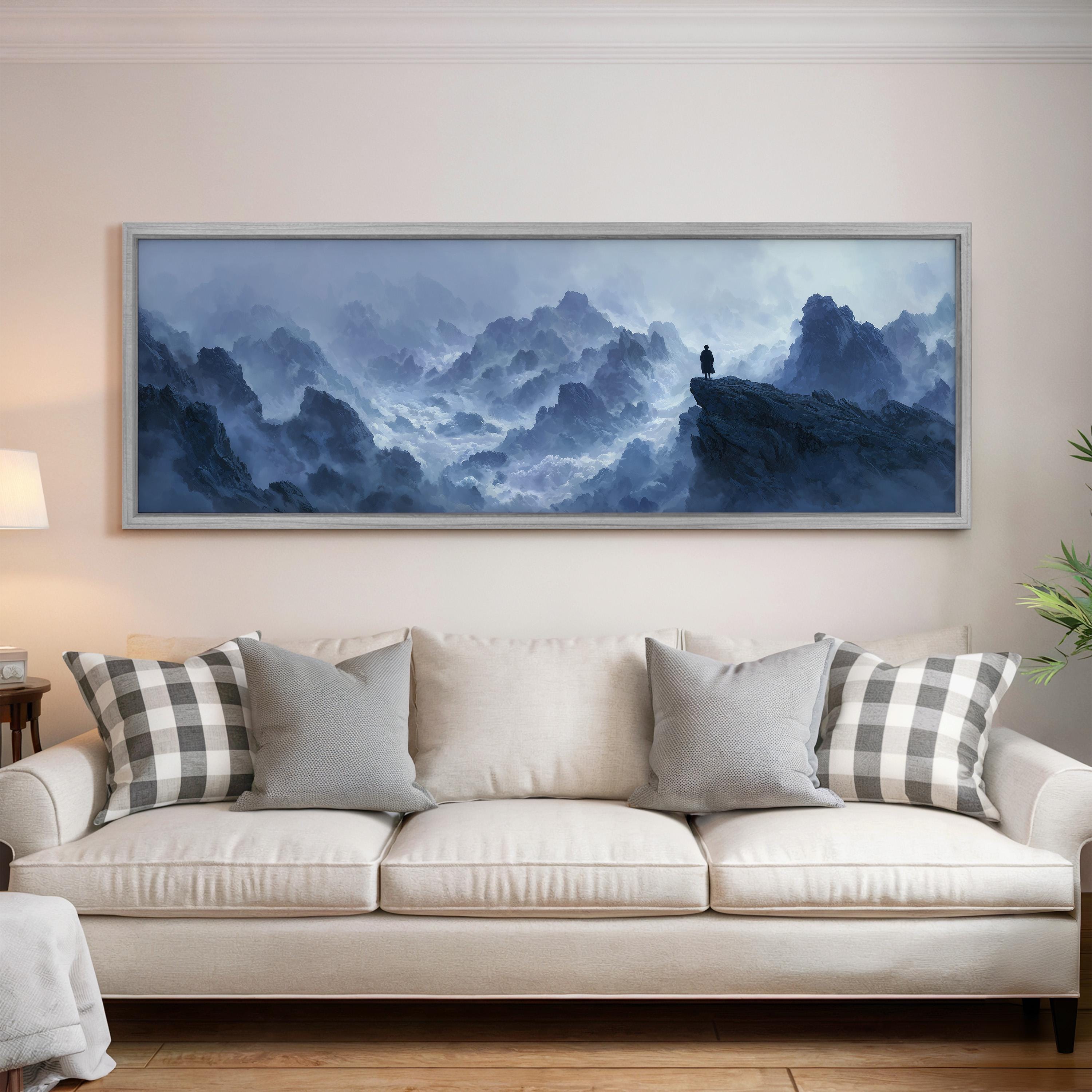 a large, framed painting of a mountainous landscape hanging on a wall above a white couch with gray and white plaid throw pillows.