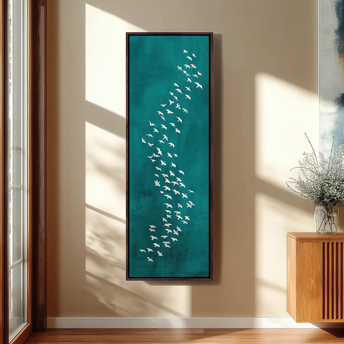 a large framed artwork depicting a flock of white birds against a teal background, hanging on a wall in a modern kitchen.