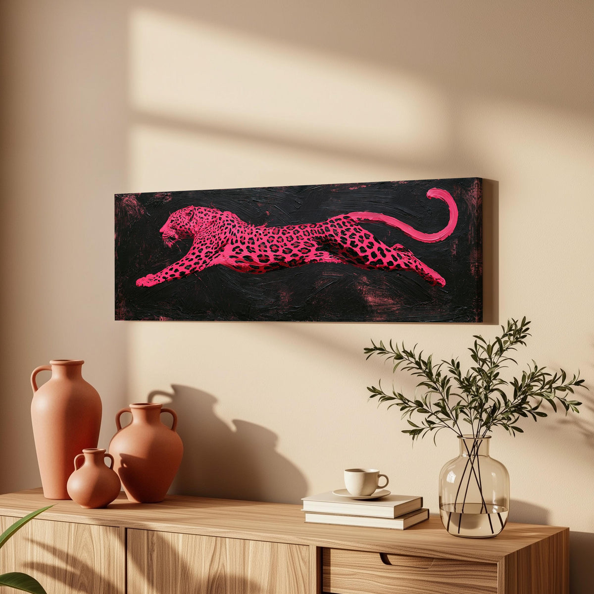 Pink leaping leopard long horizontal canvas print above a wooden sideboard