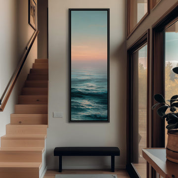 a hallway with a large painting of a serene ocean scene hanging on the wall. The painting is framed in black and is positioned above a bench. The hallway has wooden stairs leading up to the painting, and there is a window on the right side of the image.