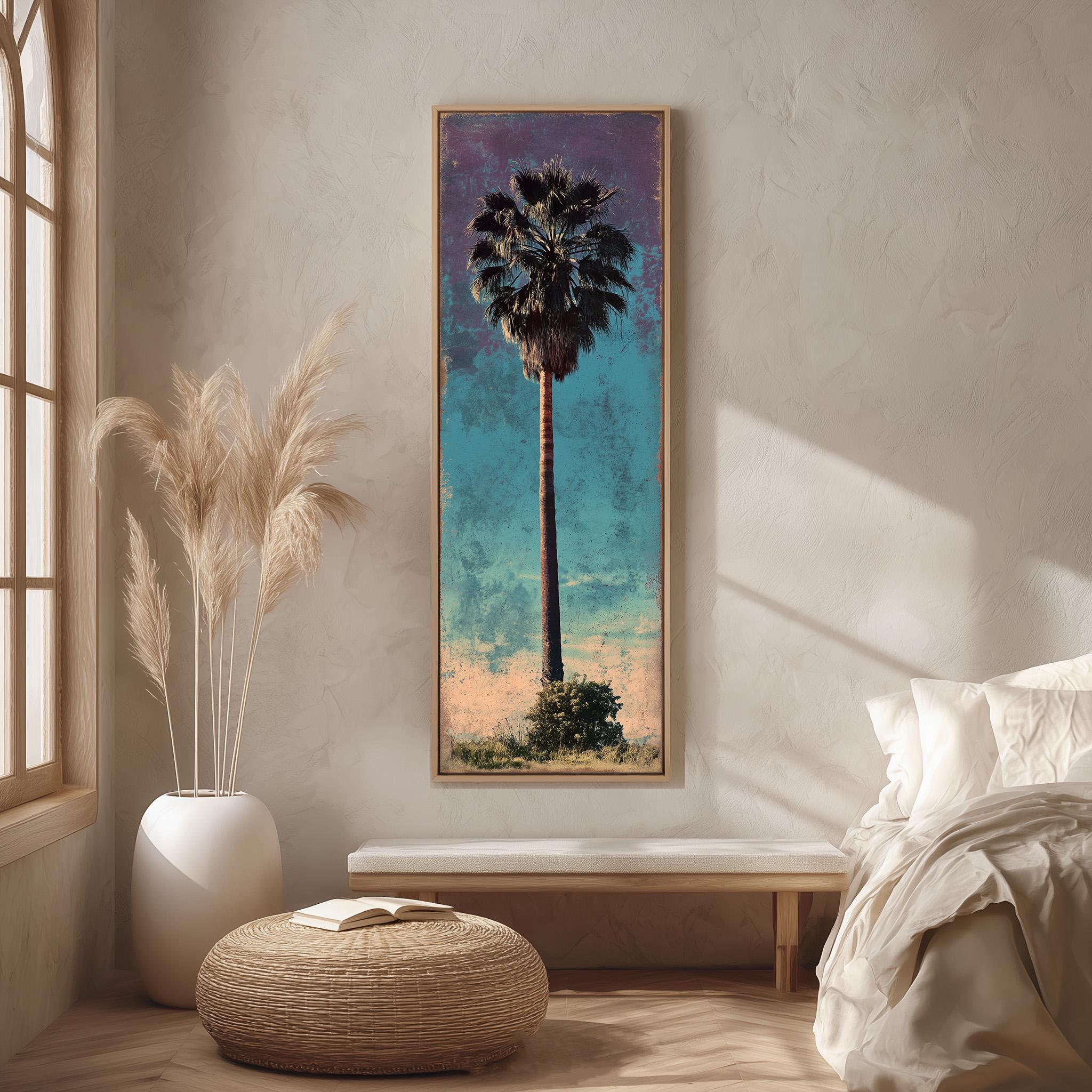 a large framed painting of a palm tree hanging on a wall in a room with a bed, a wicker ottoman, and a potted plant.