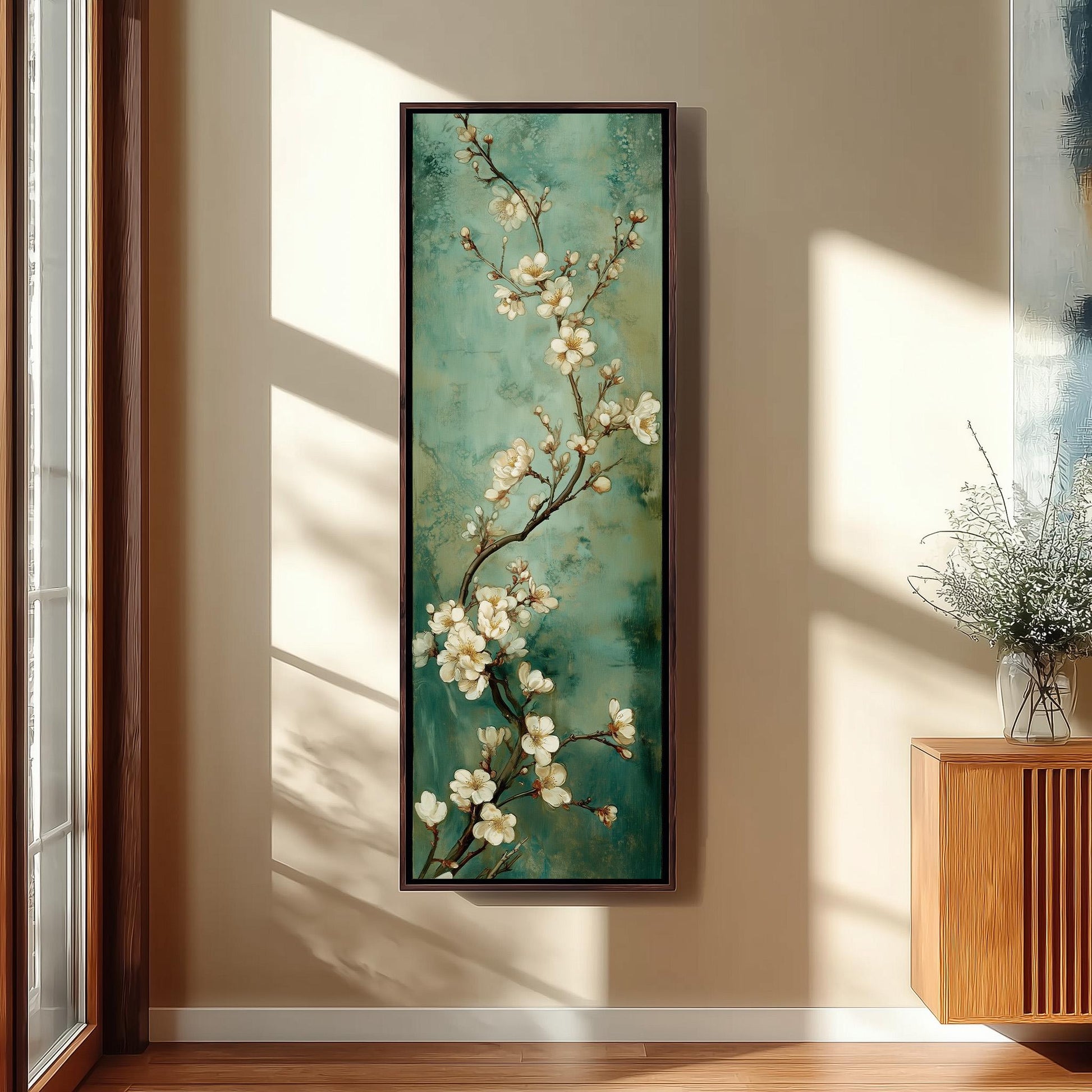 a large painting of a branch with white flowers hanging on a wall.