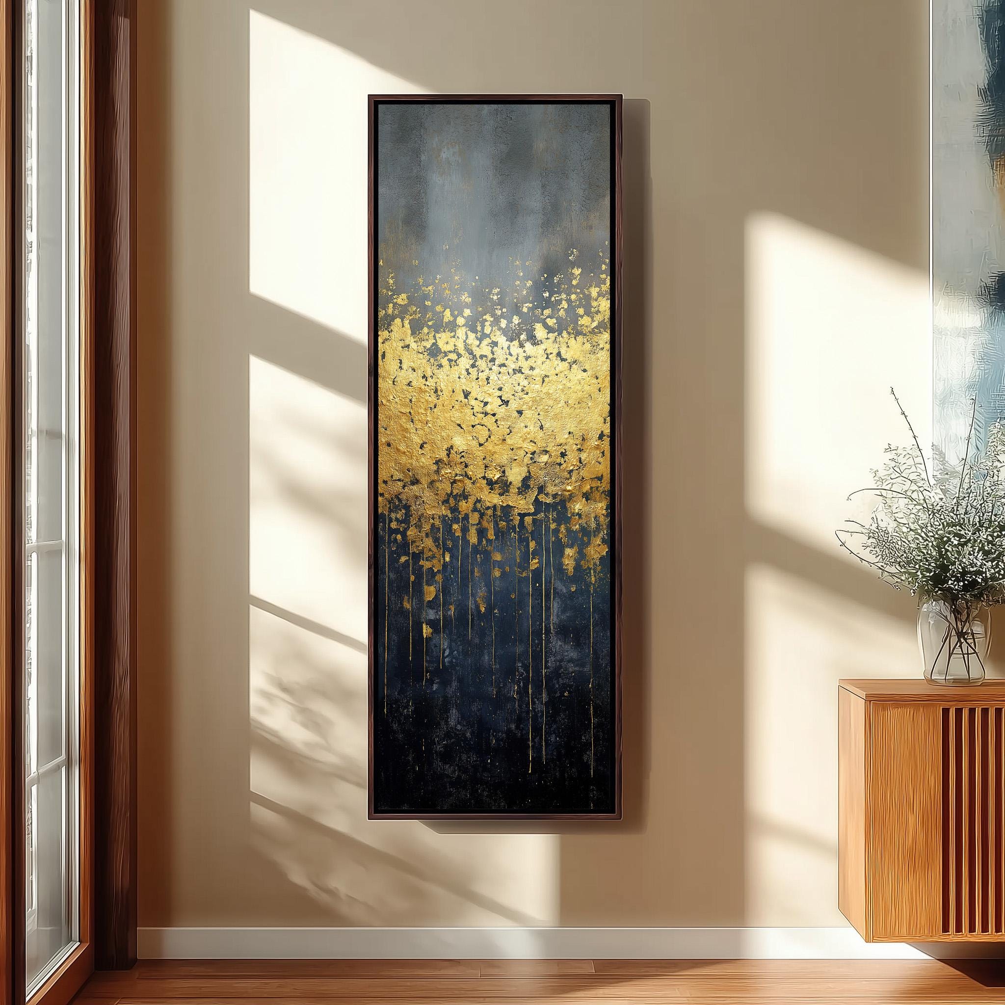 a large, rectangular painting hanging on a wall in a room with a wooden floor and a window. The painting has a dark background with a vibrant yellow and black color scheme, and it appears to depict a field of flowers or foliage.