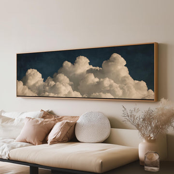 Cumulus clouds against a dark night sky long horizontal canvas print above a sofa in a living room