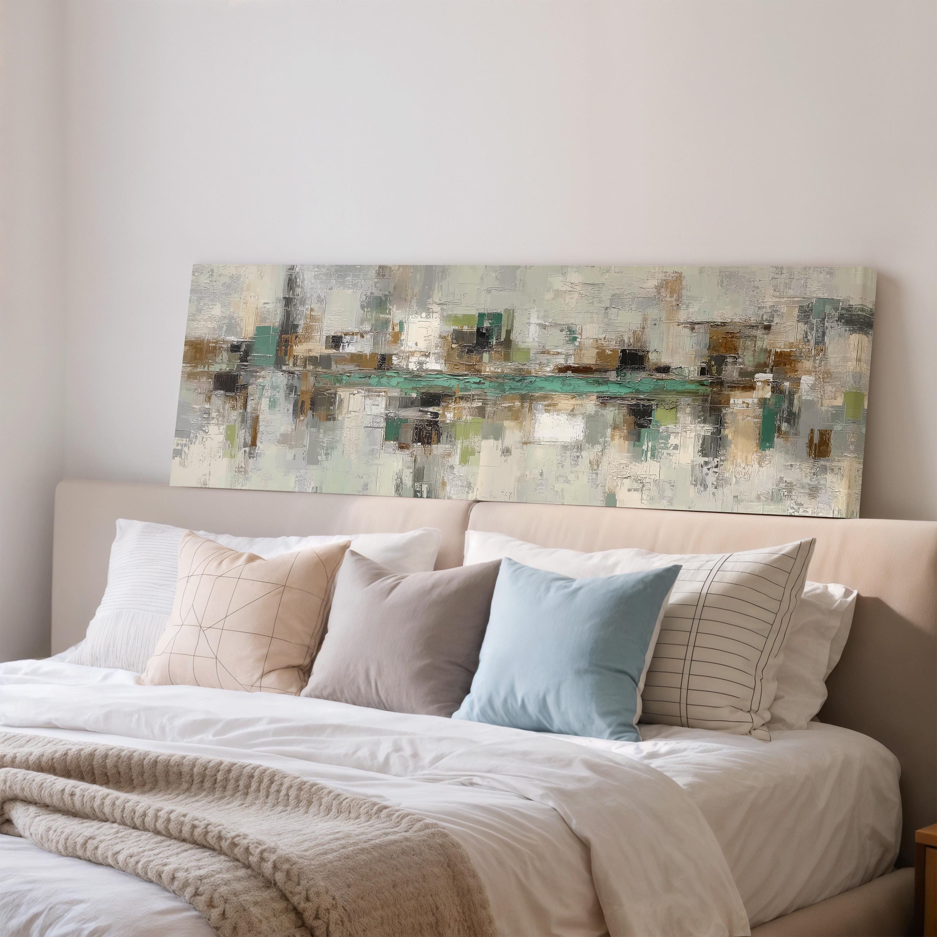 a large abstract painting hanging on a wall above a bed with white bedding and multiple pillows.