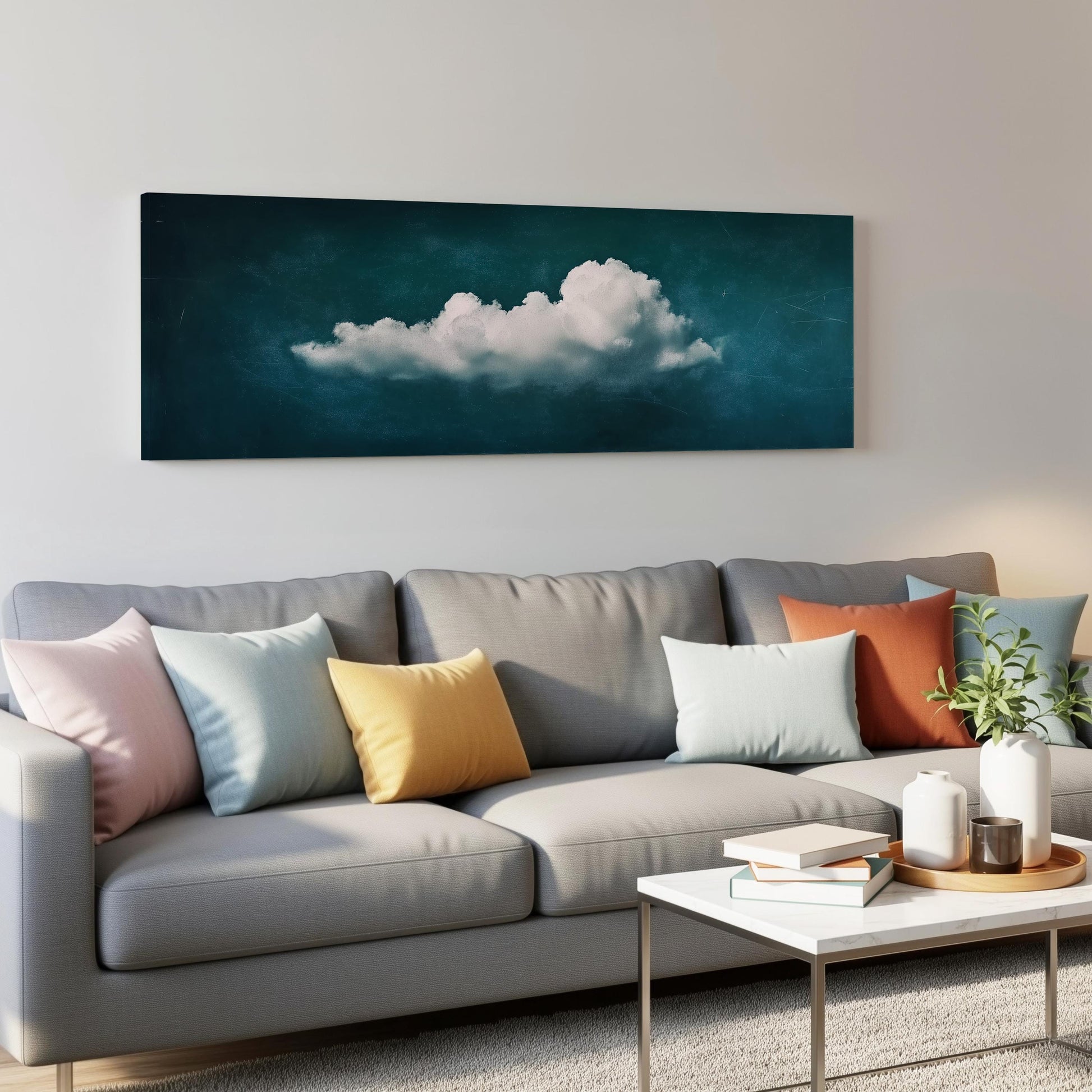 a gray couch with colorful throw pillows, a coffee table, and a large framed artwork depicting a cloud on the wall above the couch.