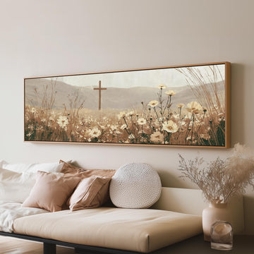 Wooden cross in a cream wildflower field long horizontal canvas print above a sofa in a living room