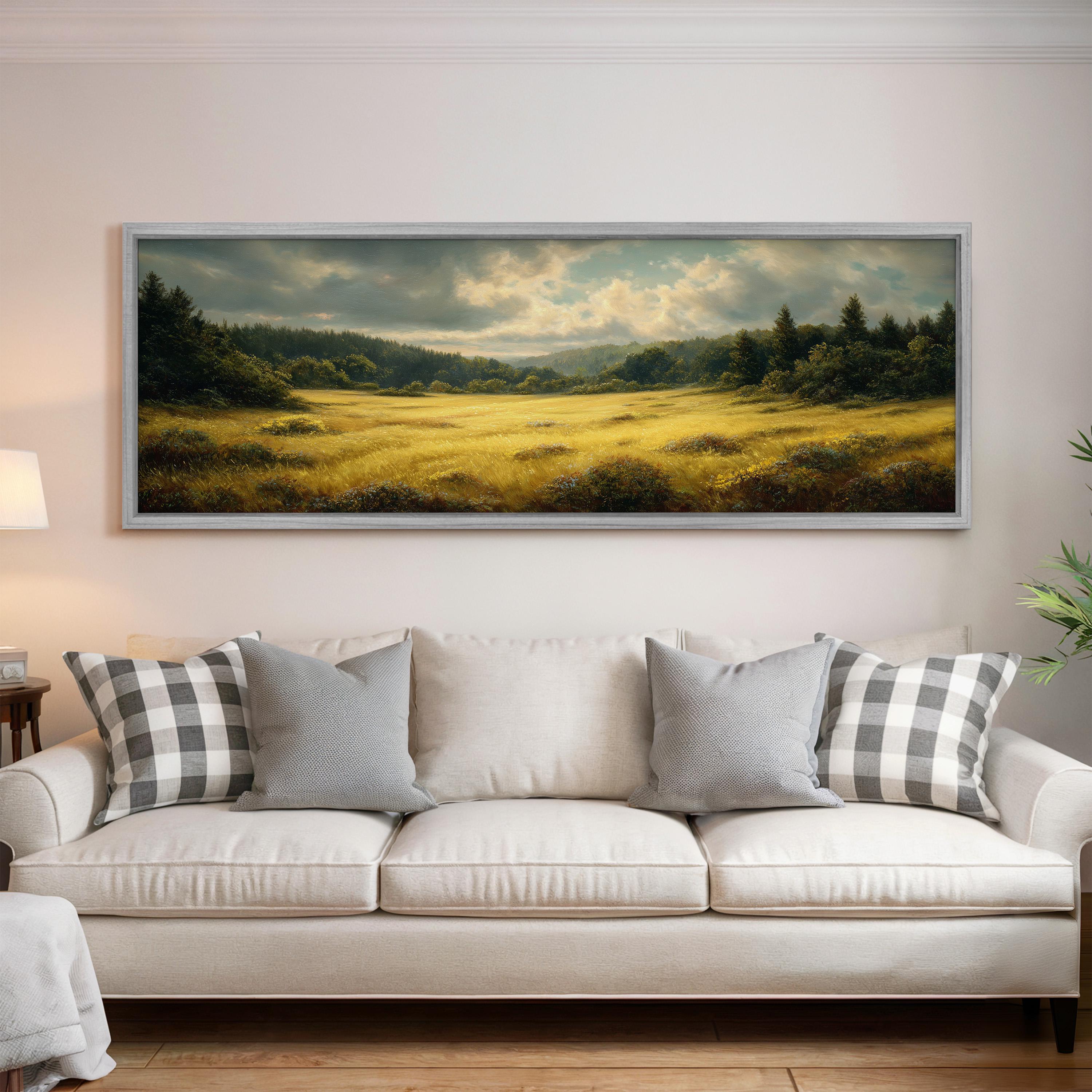 a large landscape painting hanging on a wall above a white sofa with gray and white patterned pillows.
