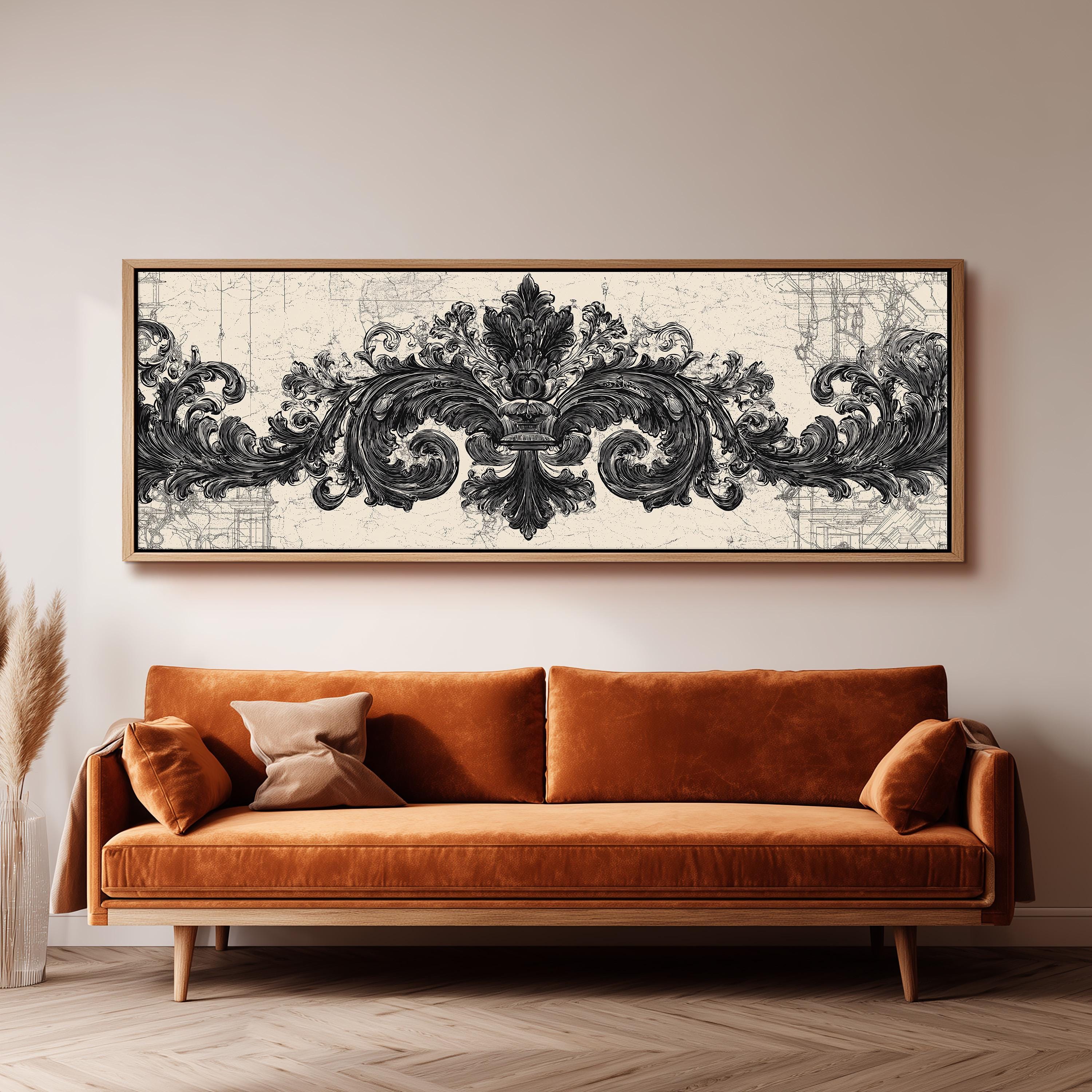 a large, ornate black and white artwork hanging on a wall above a brown sofa.
