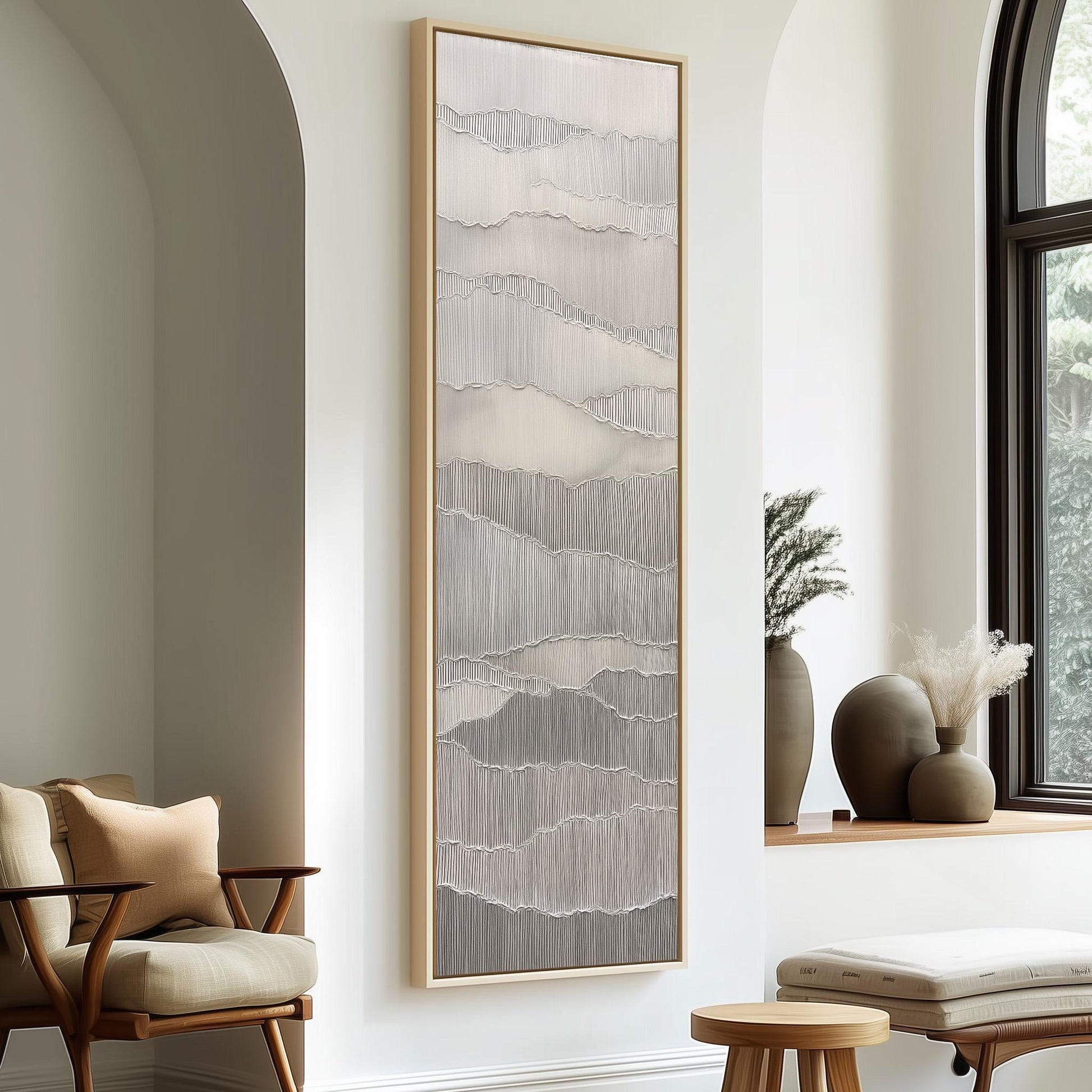 a modern living room with a large abstract painting hanging on the wall, a wooden chair, a small table, and a window with a plant on the sill.