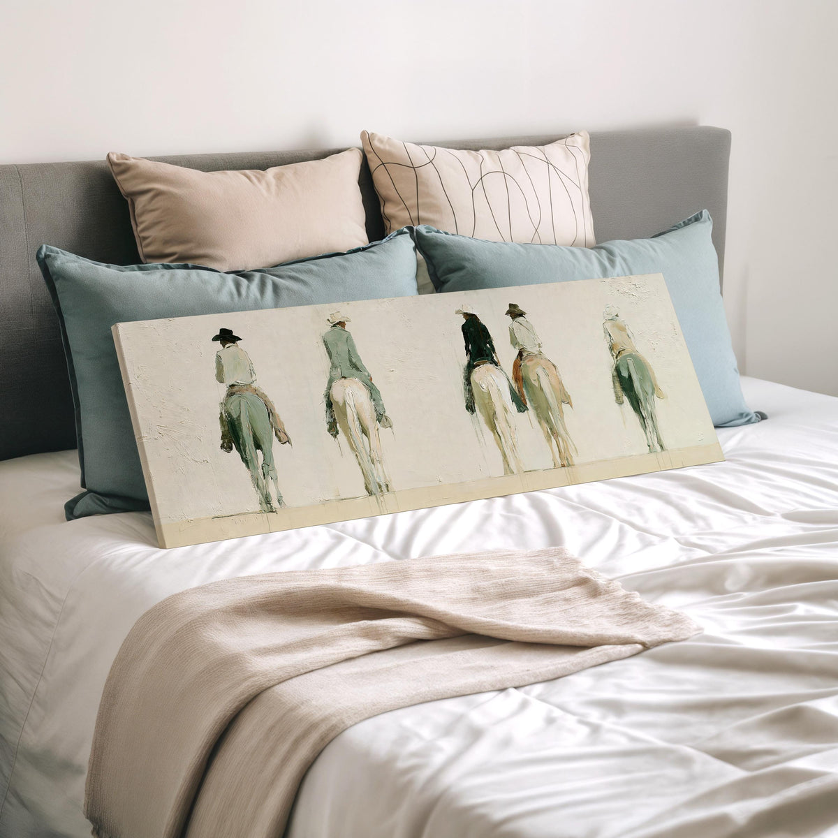 Riders on horseback seen from behind wide panoramic canvas print laid on a bed to show its size