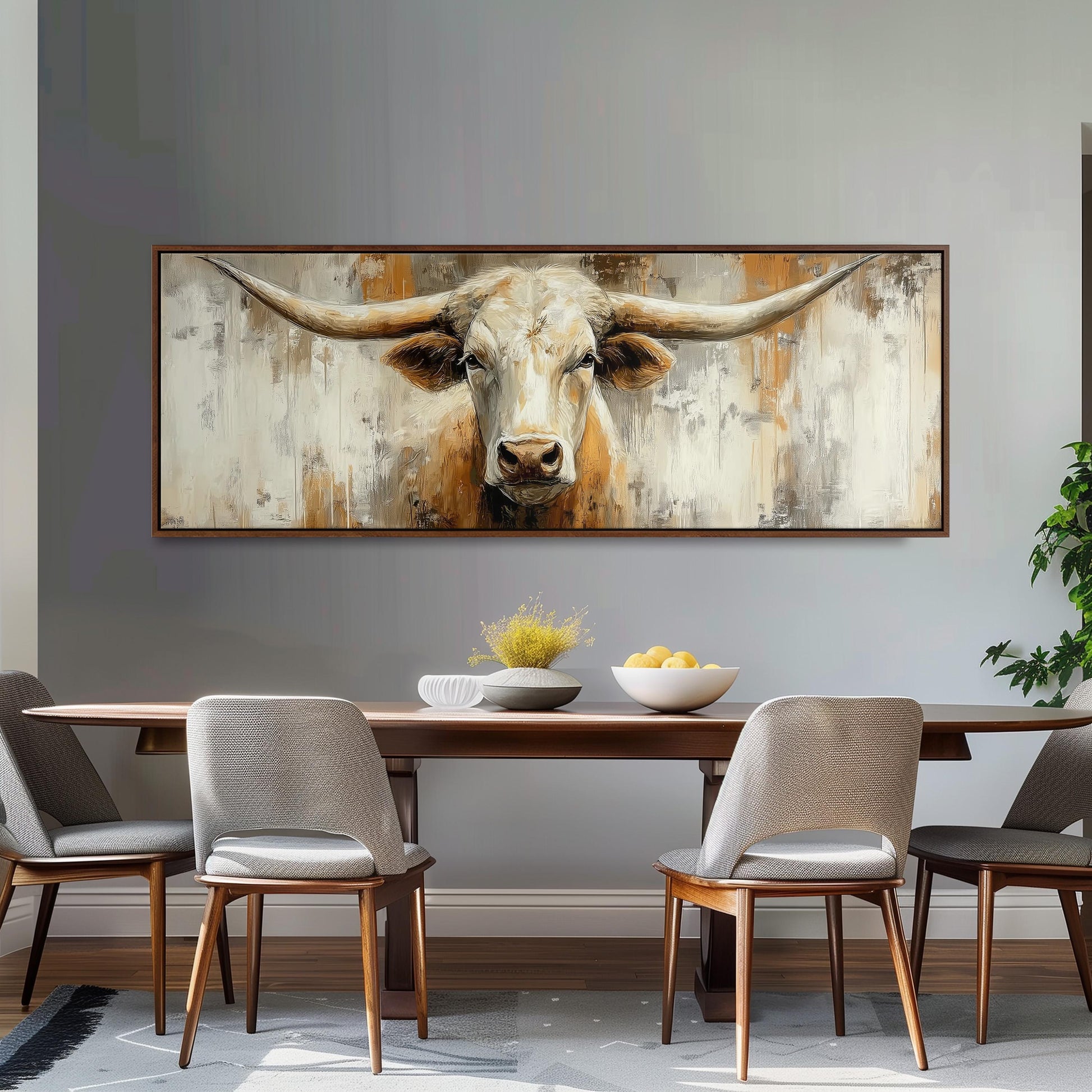 a large painting of a bull's head hanging on a wall above a wooden dining table with four chairs.