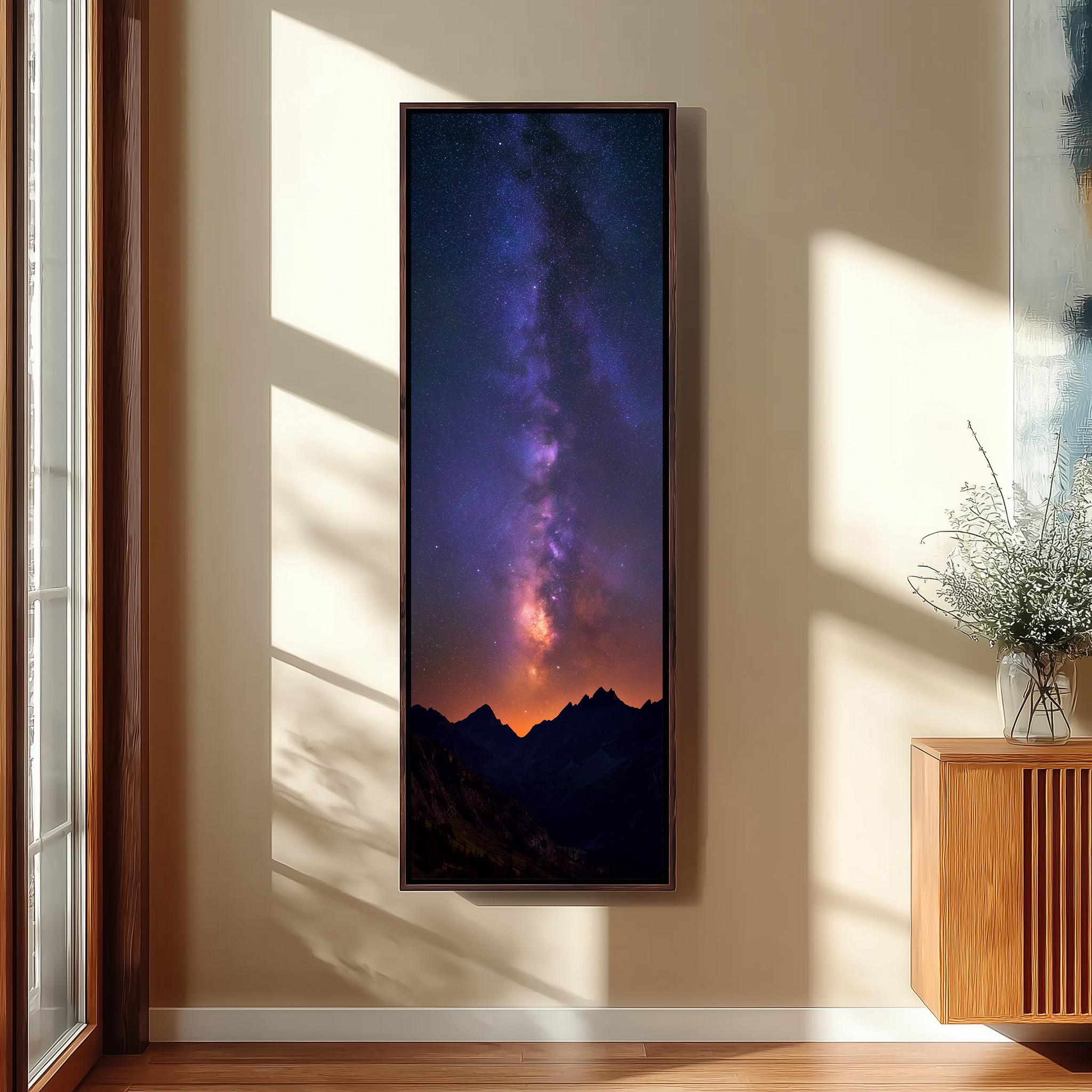 a large framed picture of a night sky with a stunning view of the Milky Way galaxy, hanging on a wall in a room with a wooden cabinet and a vase of flowers.