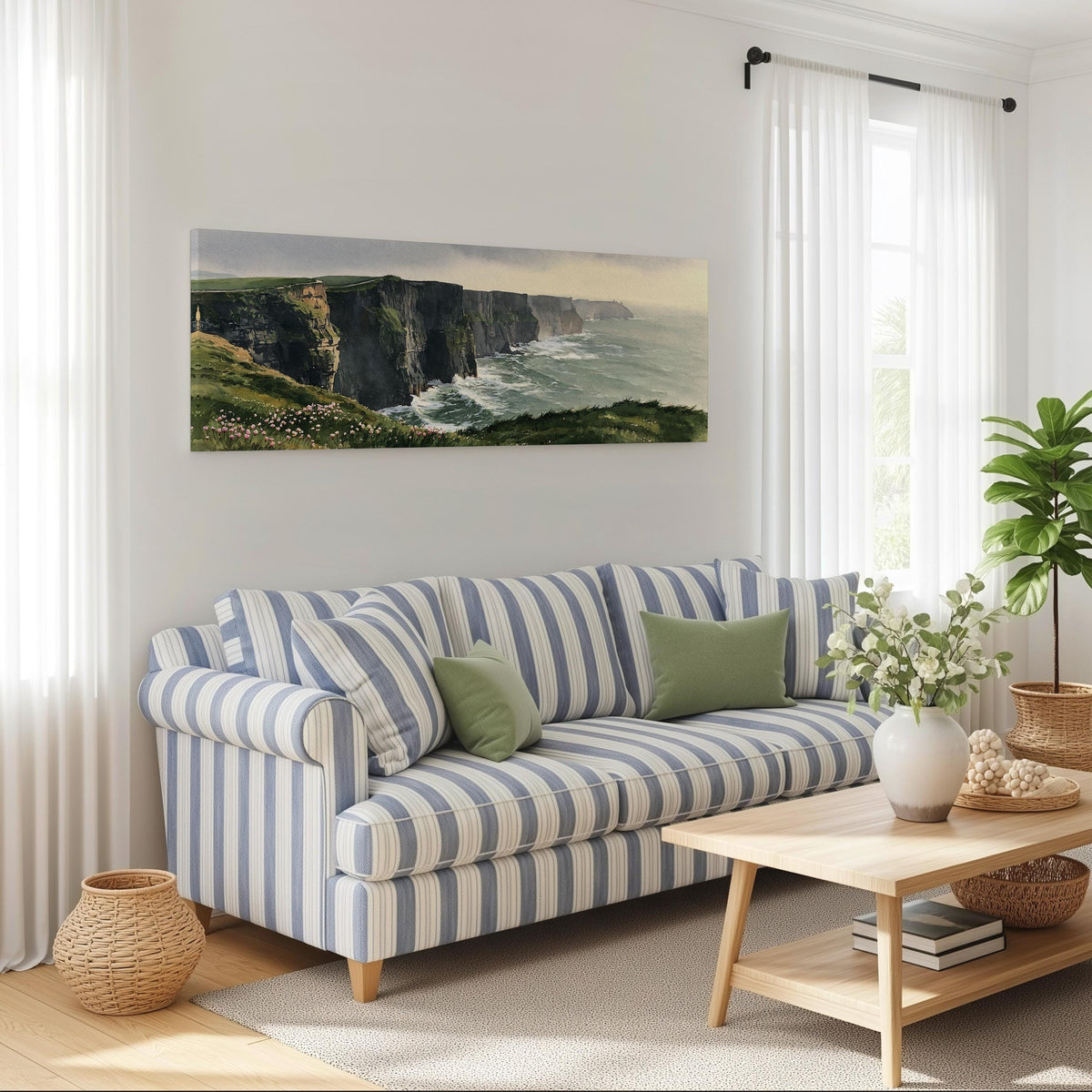Green sea cliffs with wildflowers long horizontal canvas print above a striped sofa in a coastal living room