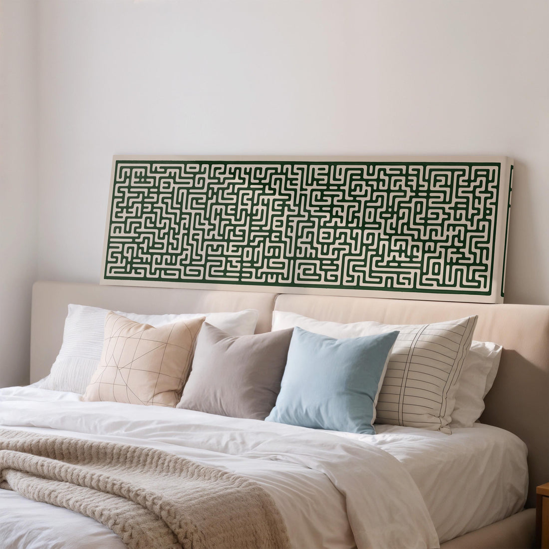 a wooden cabinet with a large green maze-like artwork hanging on the wall above it. The cabinet also has three orange vases and a glass vase with greenery on top.