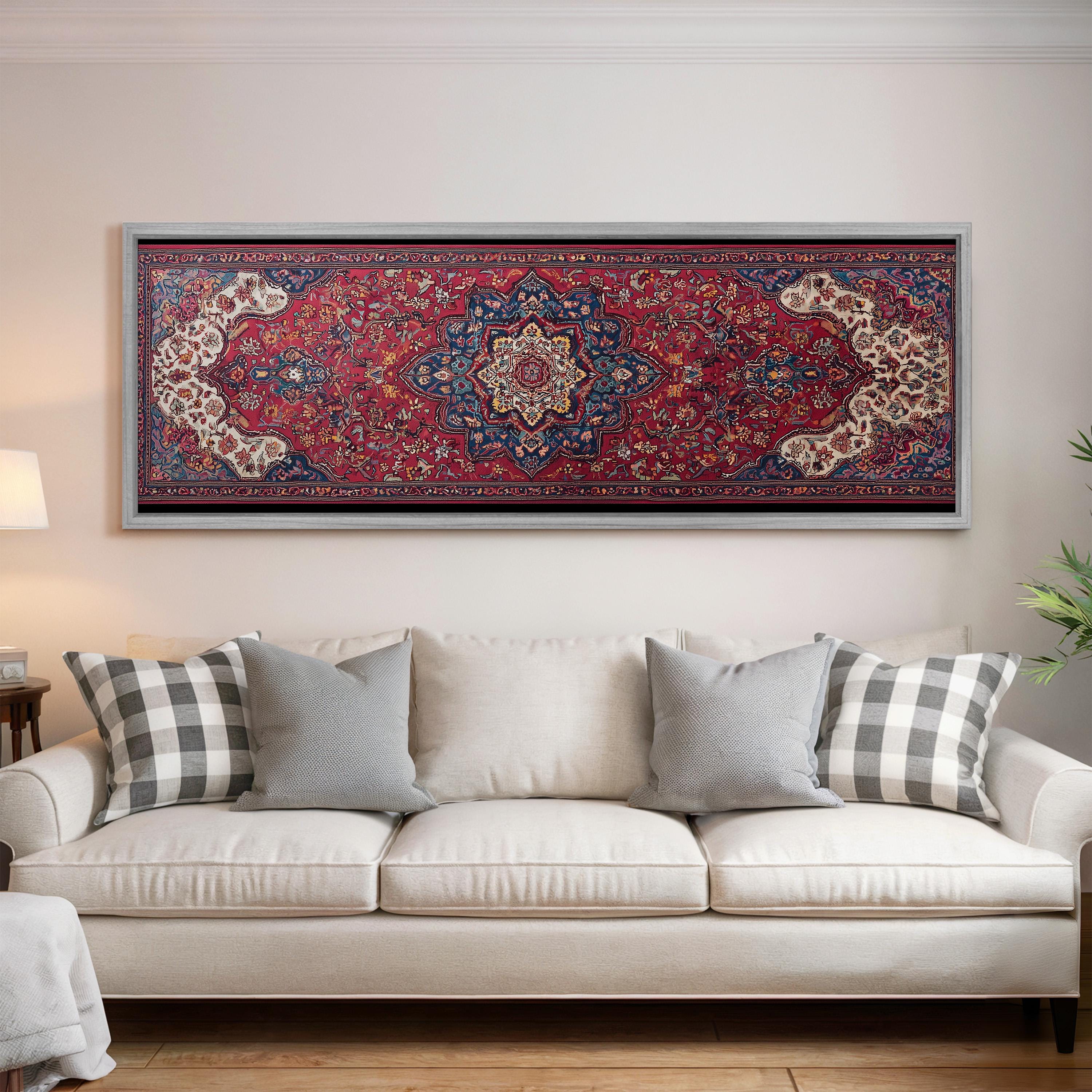a large, colorful rug hanging on a wall above a white couch with gray and white pillows.