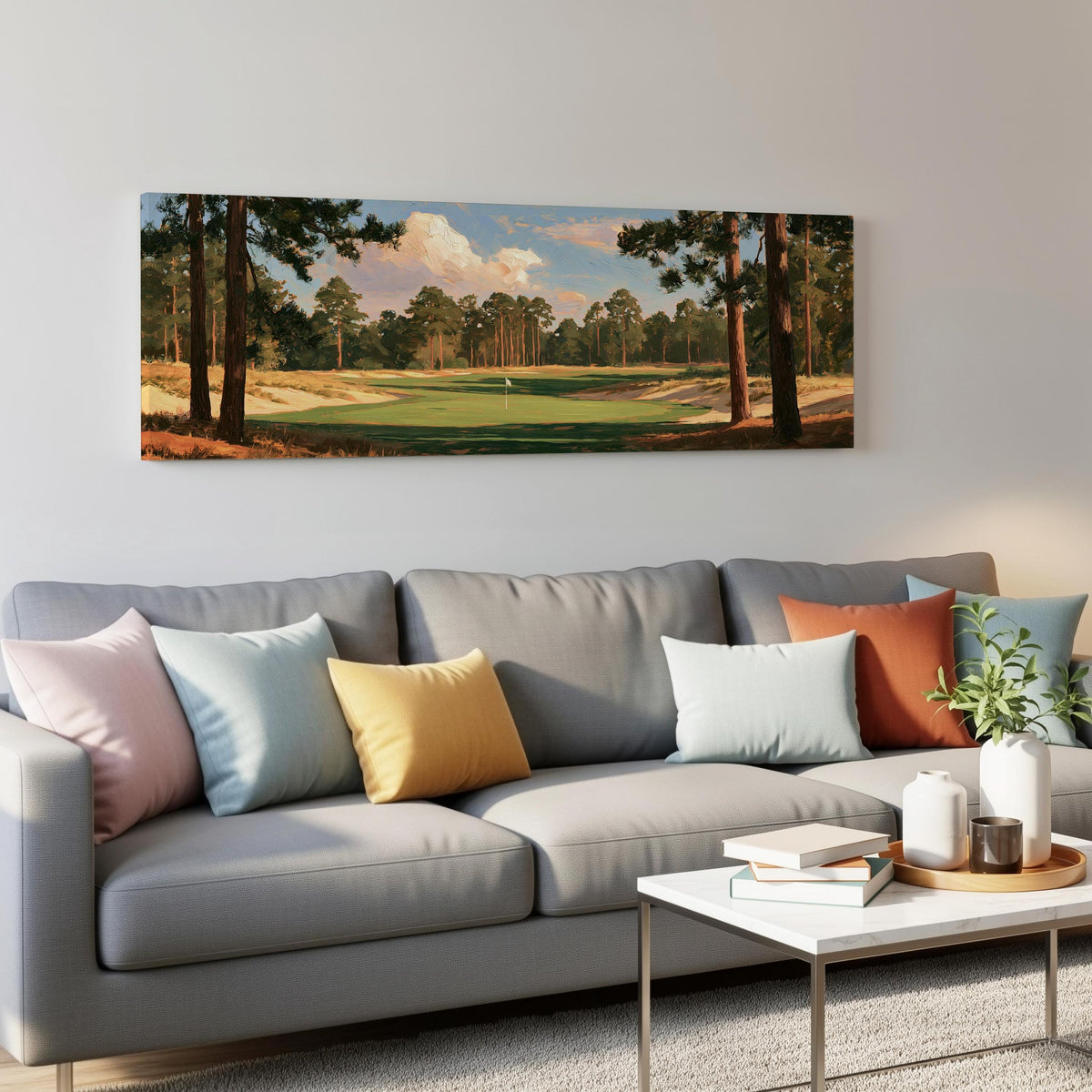 Golf fairway lined with tall pines panoramic canvas print above a grey sofa in a living room