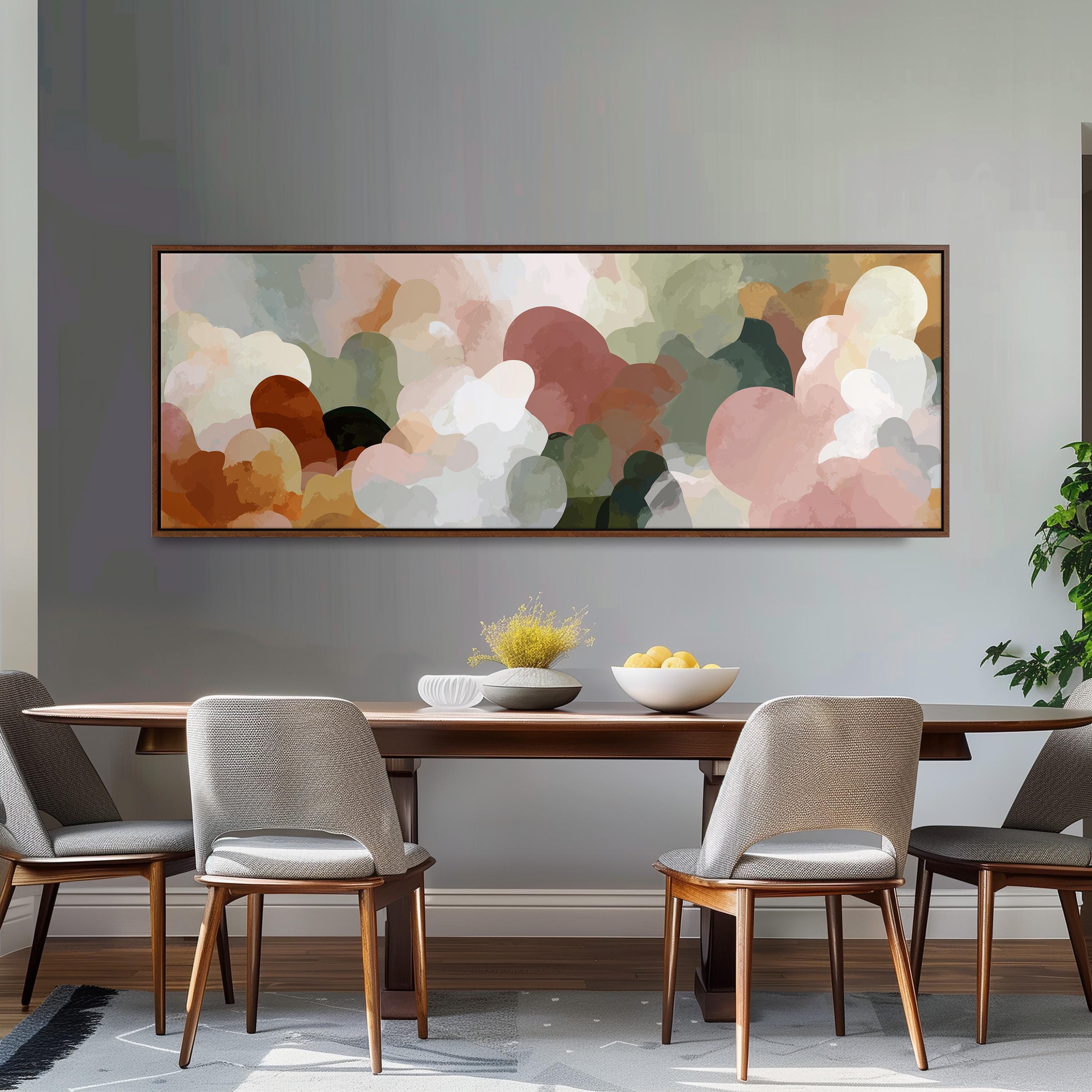 a dining room with a wooden table and four chairs. Above the table, there is a large abstract painting with a colorful, organic design. The painting is framed and hangs on the wall above the table.